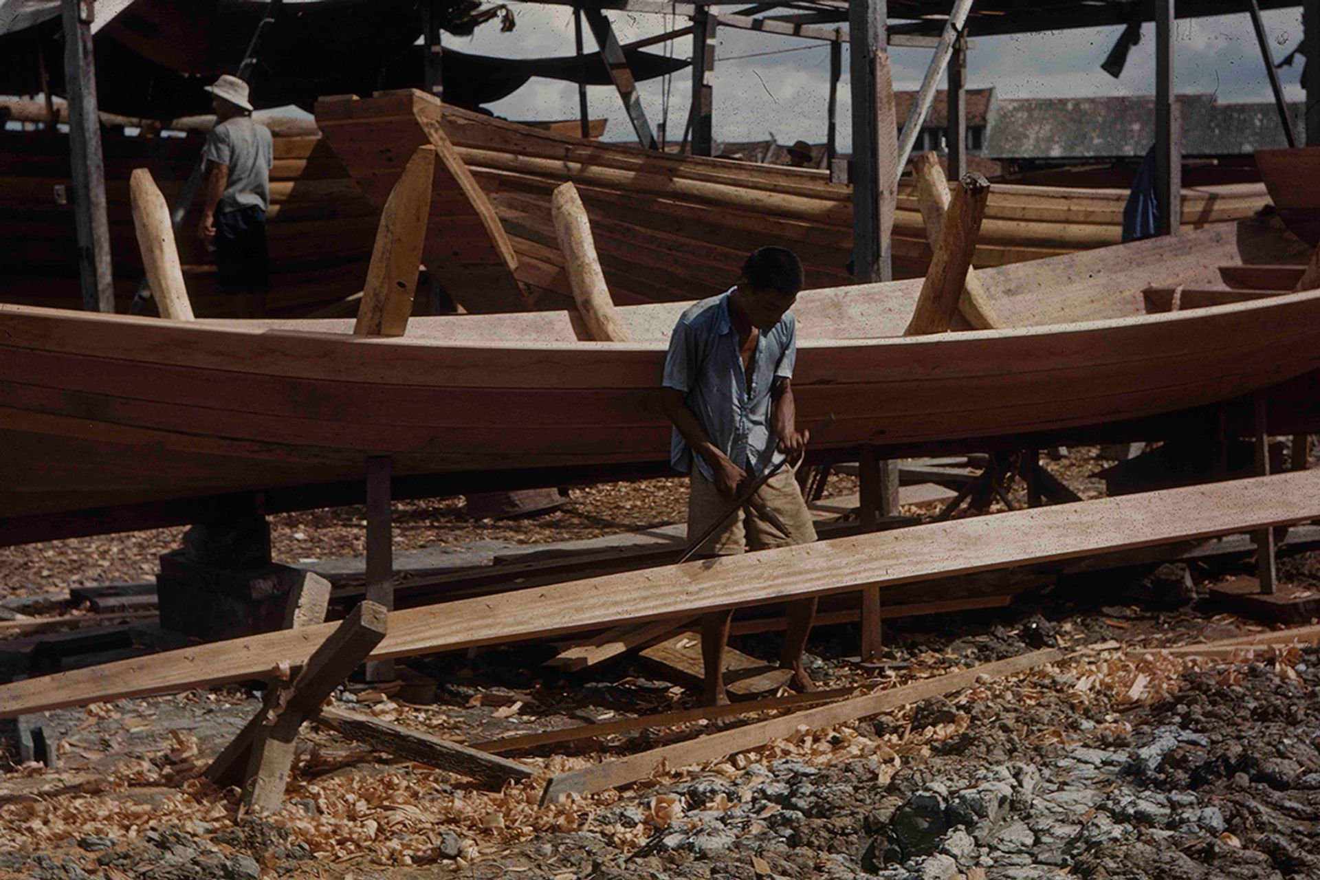 On a narrow strip of land between Beach Road and the sea wall, wooden sea-going vessels and small sampans were built using traditional tools in the 1950s.