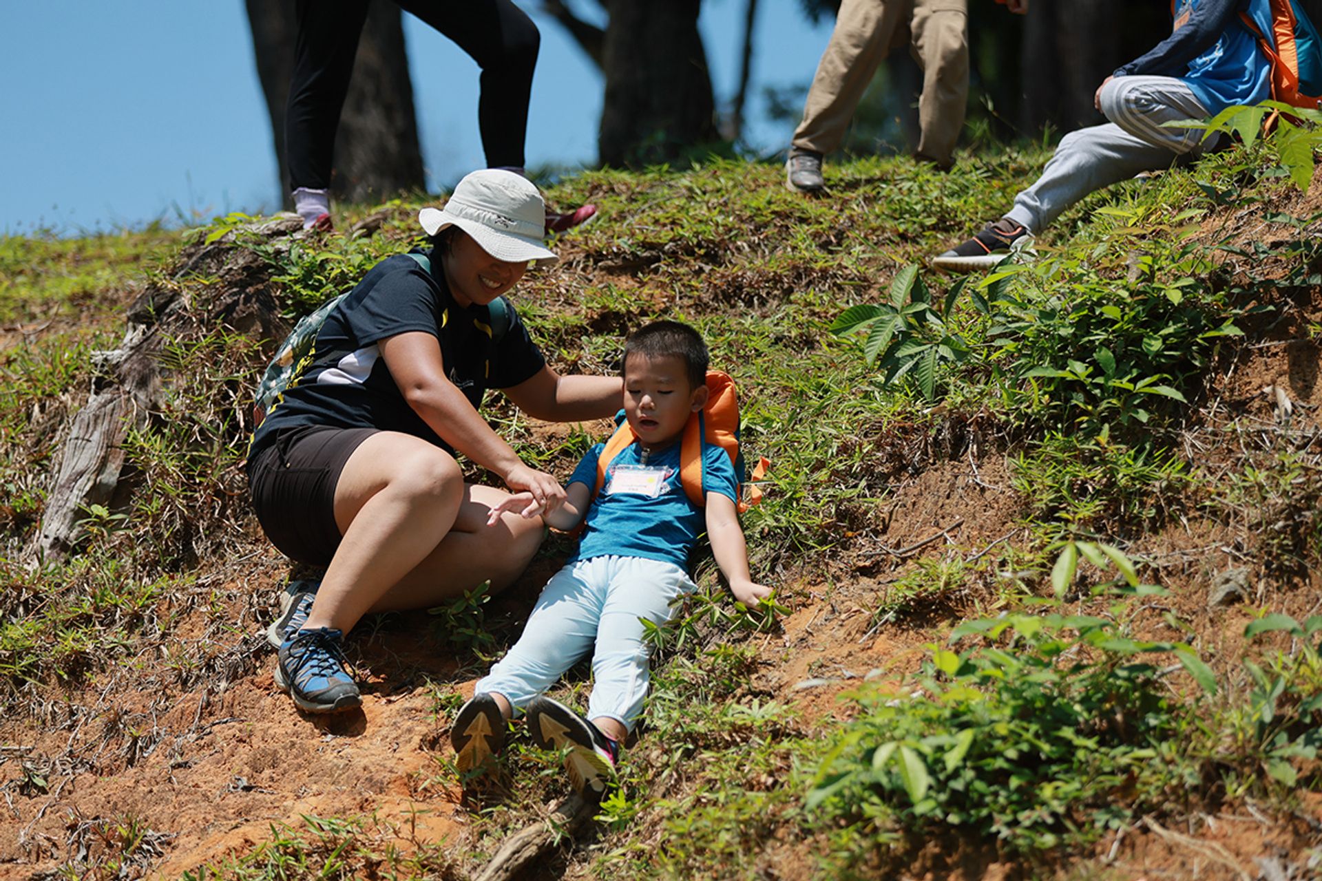 Lucas Li learns how to slide down a slope safely, with the assistance of volunteer Ng Yimin, 38.