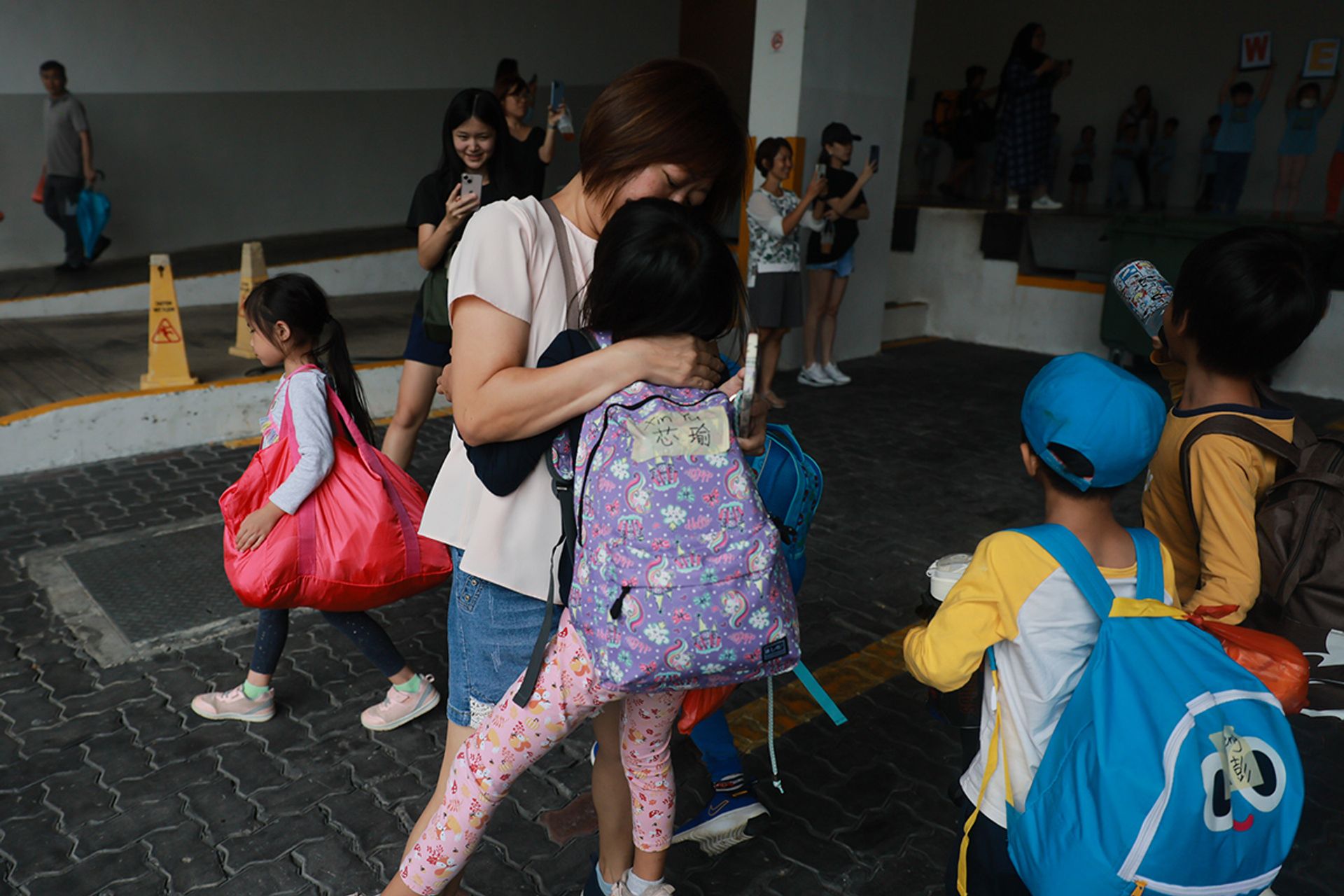 Madam Eileen Wong, 45, gives her daughter Khor Xin Yu a big hug as she returns to school from camp.