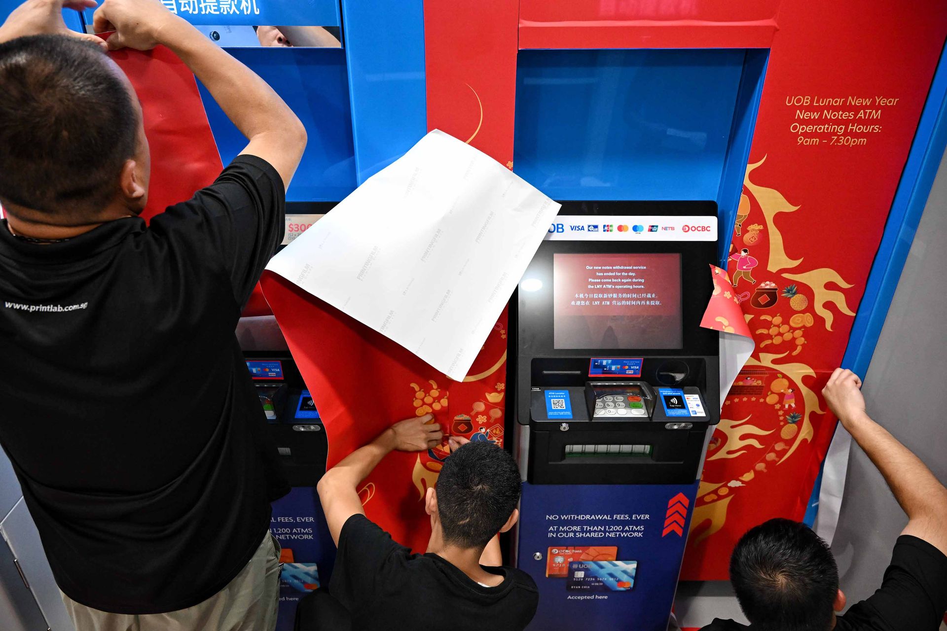 The ATMs at UOB Rochor branch in Fu Lu Shou Complex being decorated with festive decals the night before the withdrawal of new notes starts.
