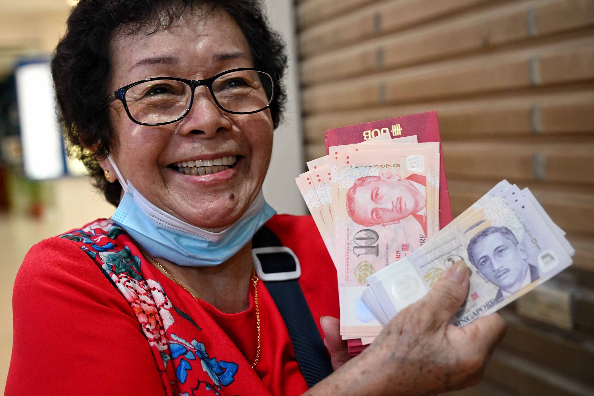 Cleaner Wong Gim Moy, 78, was one of the first few in line at UOB Rochor branch to withdraw new notes for gifting during Chinese New Year.