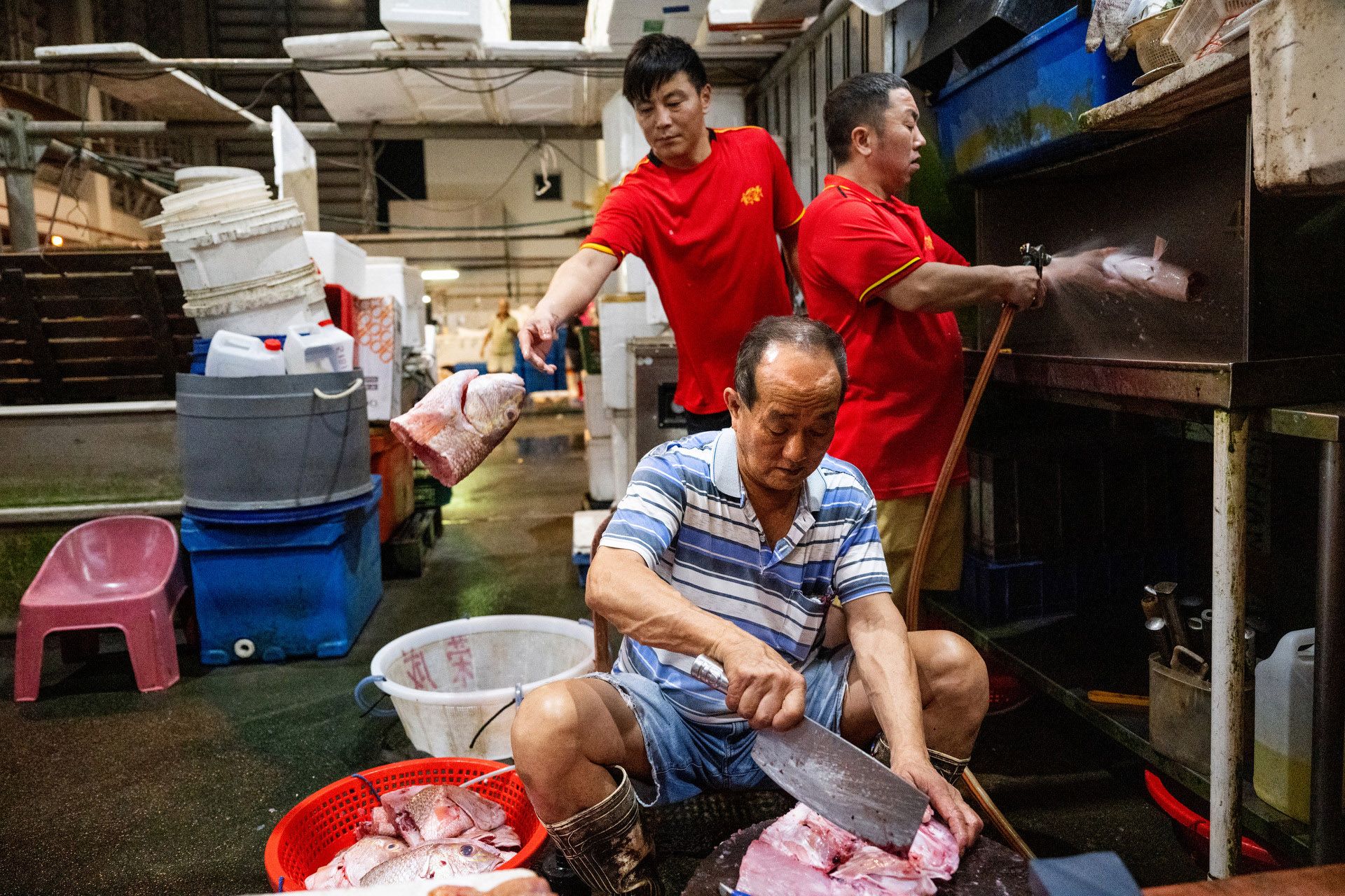 Mr Low Swee Hua (in blue), 64, cutting a fish, while two workers prepared the fish for packaging.