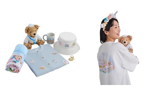 Duffy & Friends merchandise: plush bear, blanket, cardigan, hat, mug, keychains. A woman holds a bear.