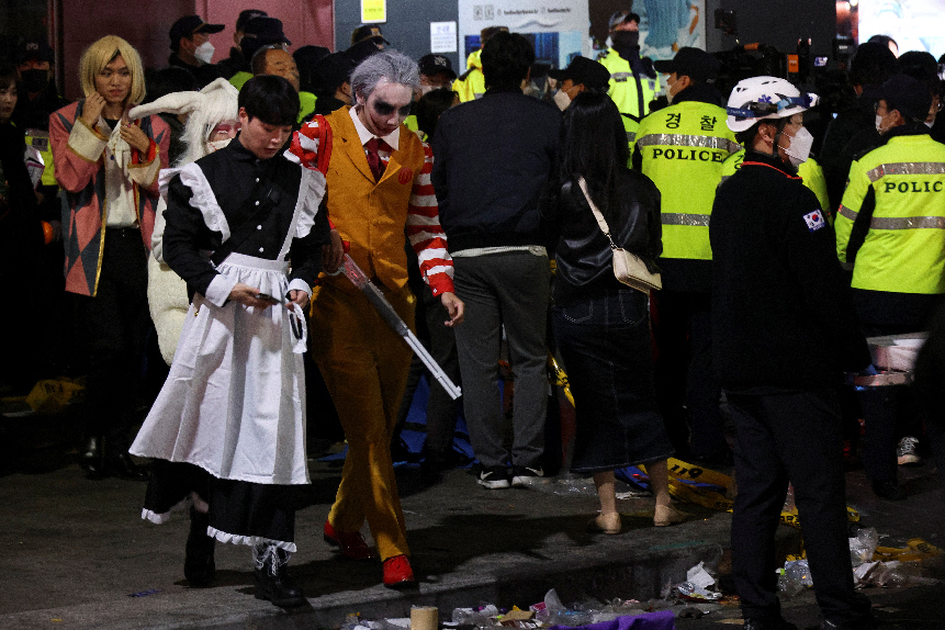Partygoers, many in Halloween costumes, leave the scene of the crowd crush. PHOTO: REUTERS