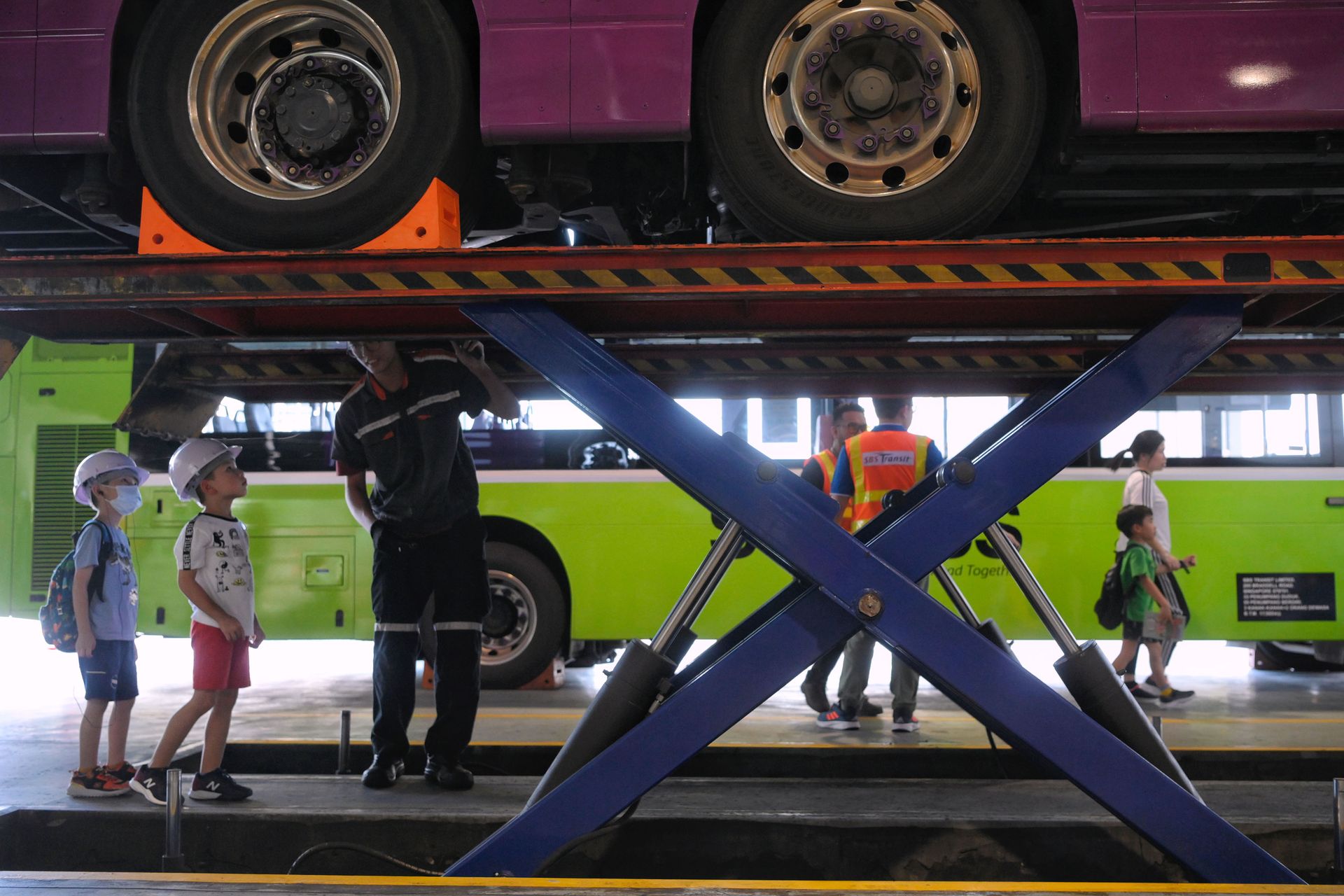 Young visitors looking at the undercarriage of a bus during a tour of the Ulu Pandan Bus Depot during a programme which was part of the Singapore HeritageFest on May 13.