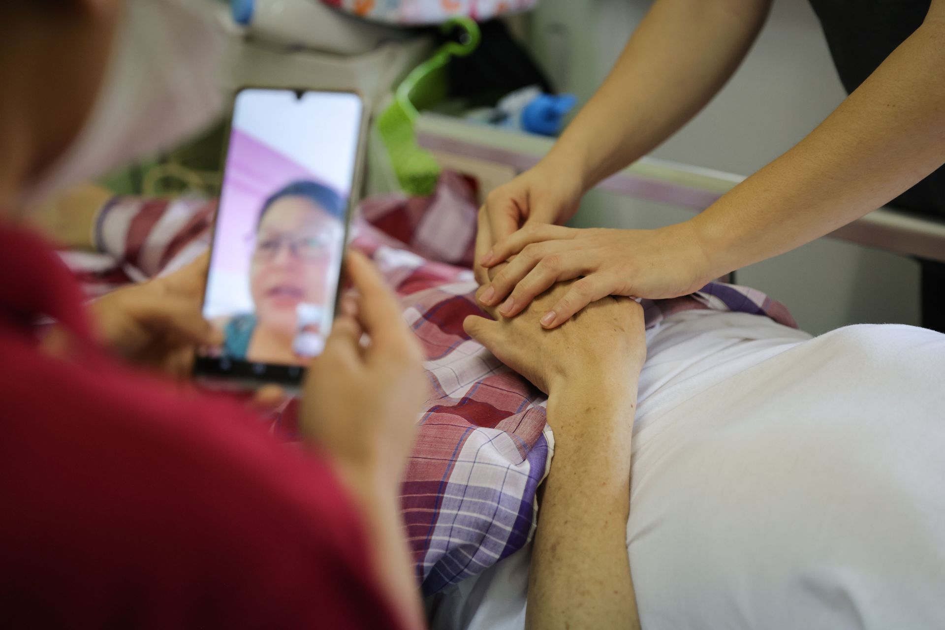A registered nurse gives Ms Moe Sapal the go-ahead for the bath via video call.