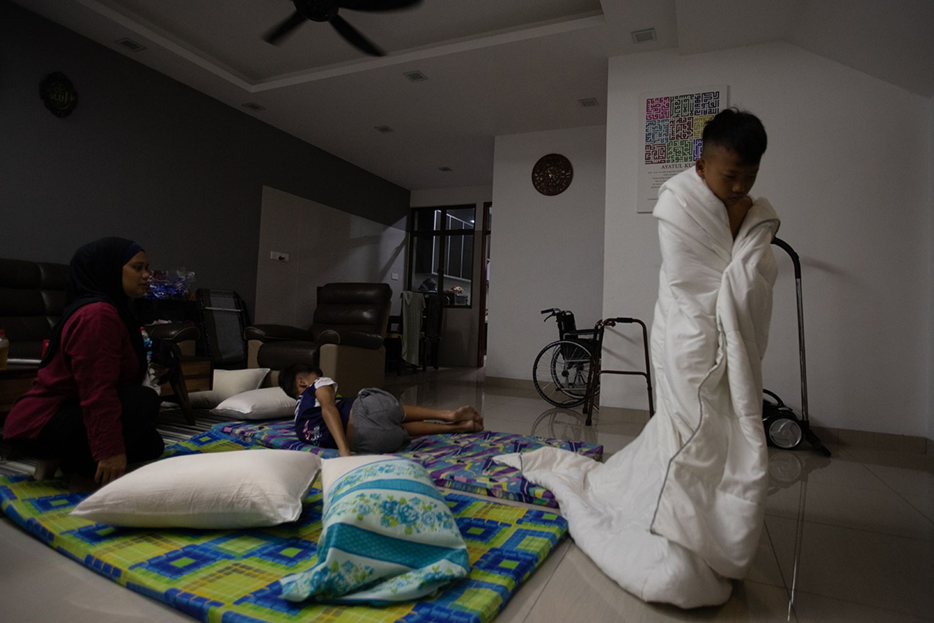 A groggy Iman wrapping himself in a blanket after his mother woke him up before 7am for training.