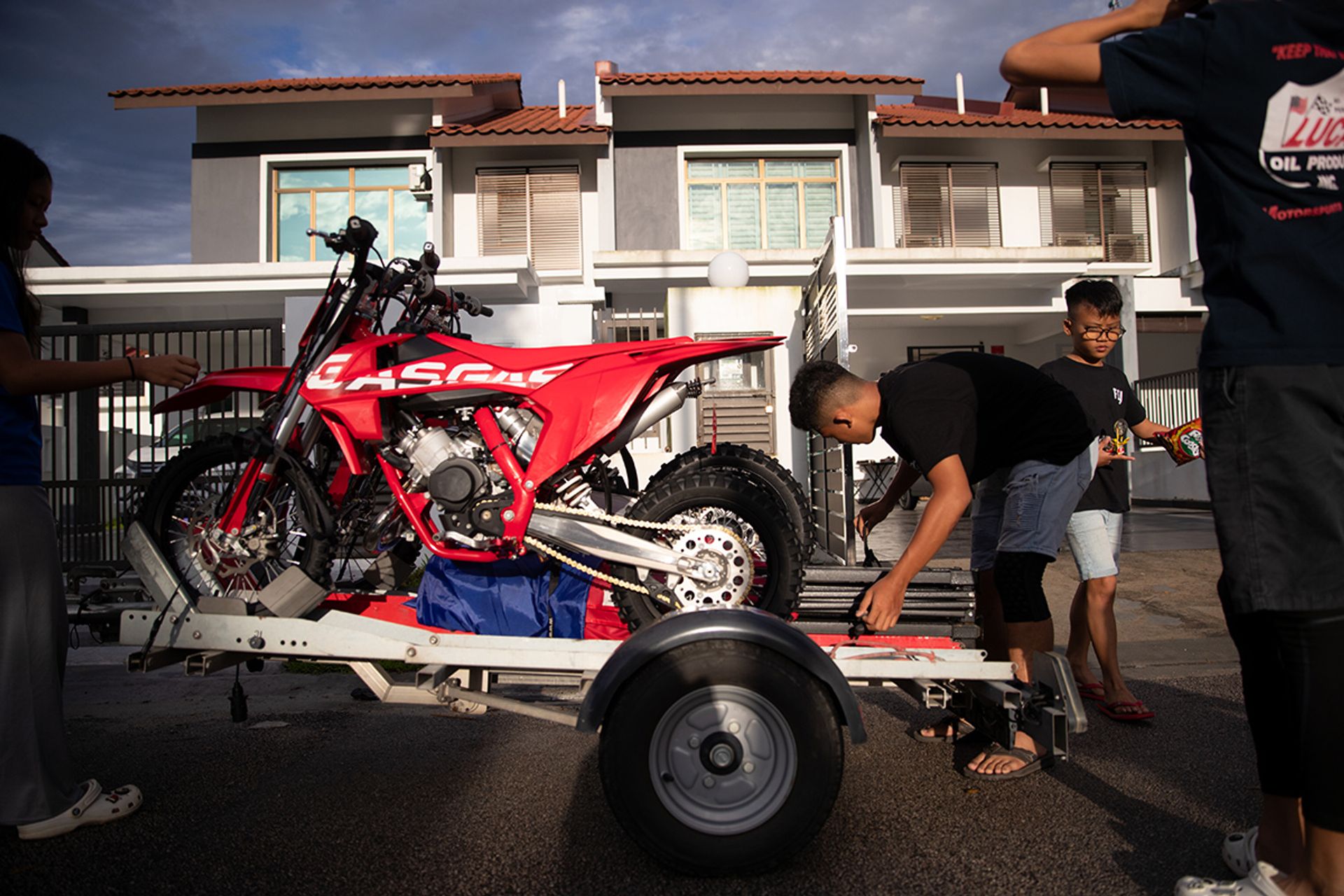 Ian strapping down the tents and dirt bikes on the trailer which will be towed to the motocross track.