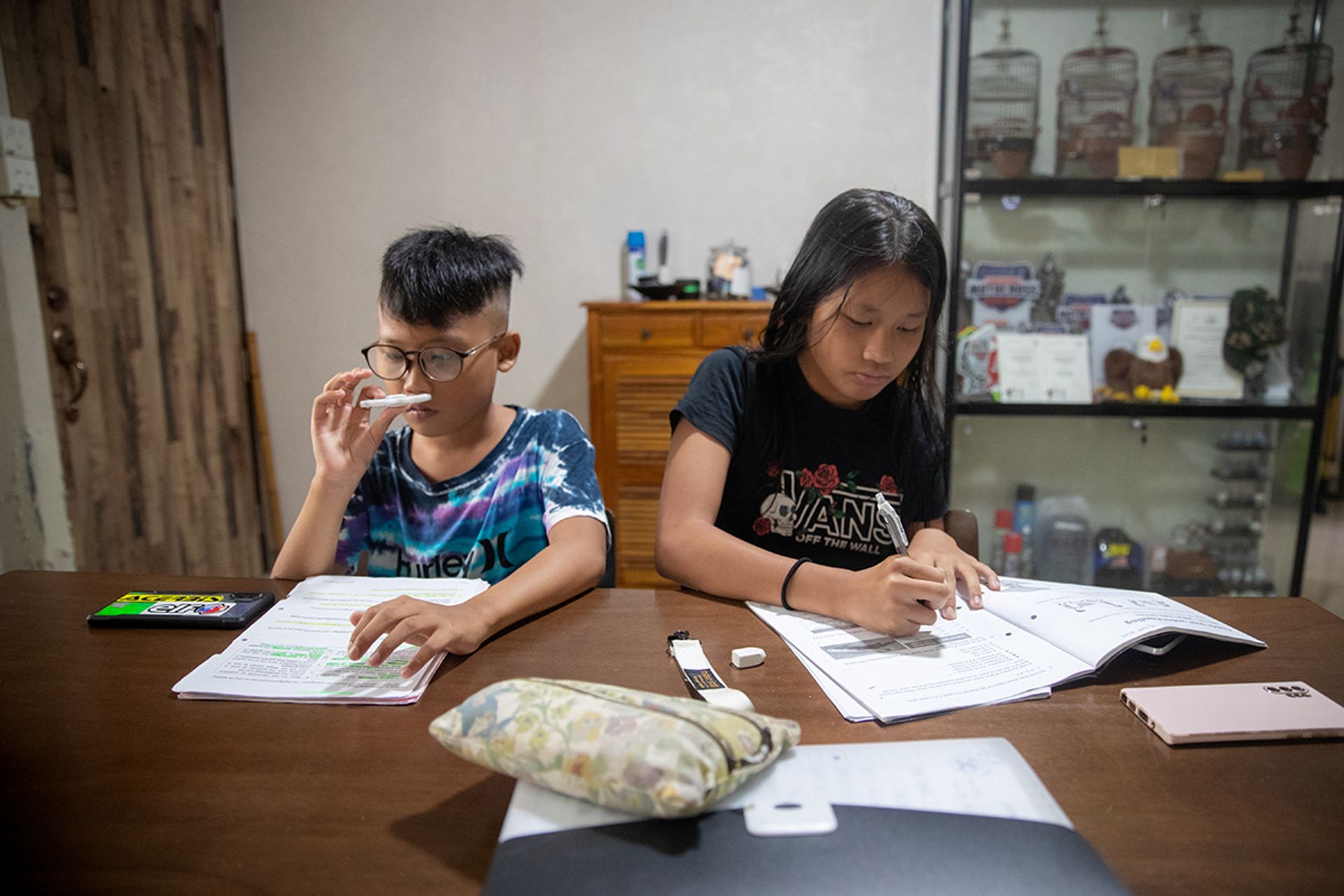 Iman and Iris doing homework in the living room of their flat before leaving for Johor on June 30.
