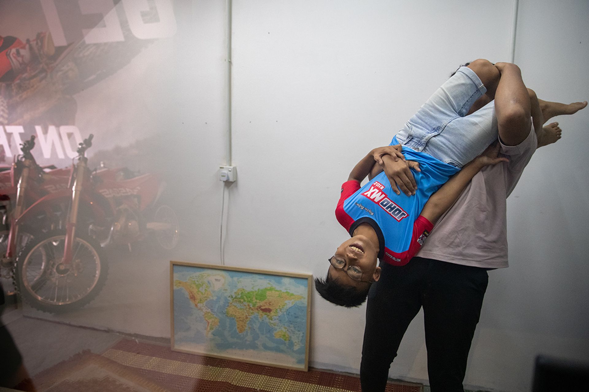 Muhammad Nurhaziq Norzahari Saiful, 15, swinging teammate Iman around at the motorcycle workshop PGM Tech 23 in Johor Bahru on July 2.