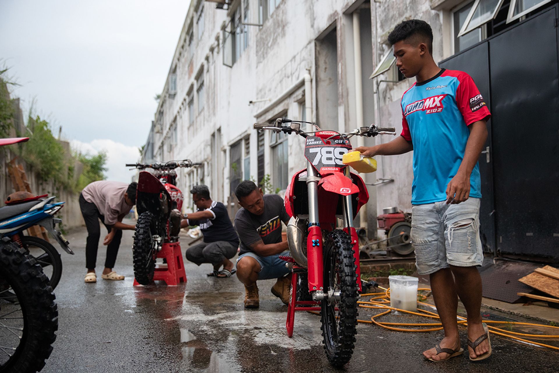 (From left) PGM Tech 23 Racing Singaporean rider Nurhaziq, his father Norzahari Saiful, Mr Fazlin and Ian washing their bikes before decals are pasted on at PGM Tech 23.