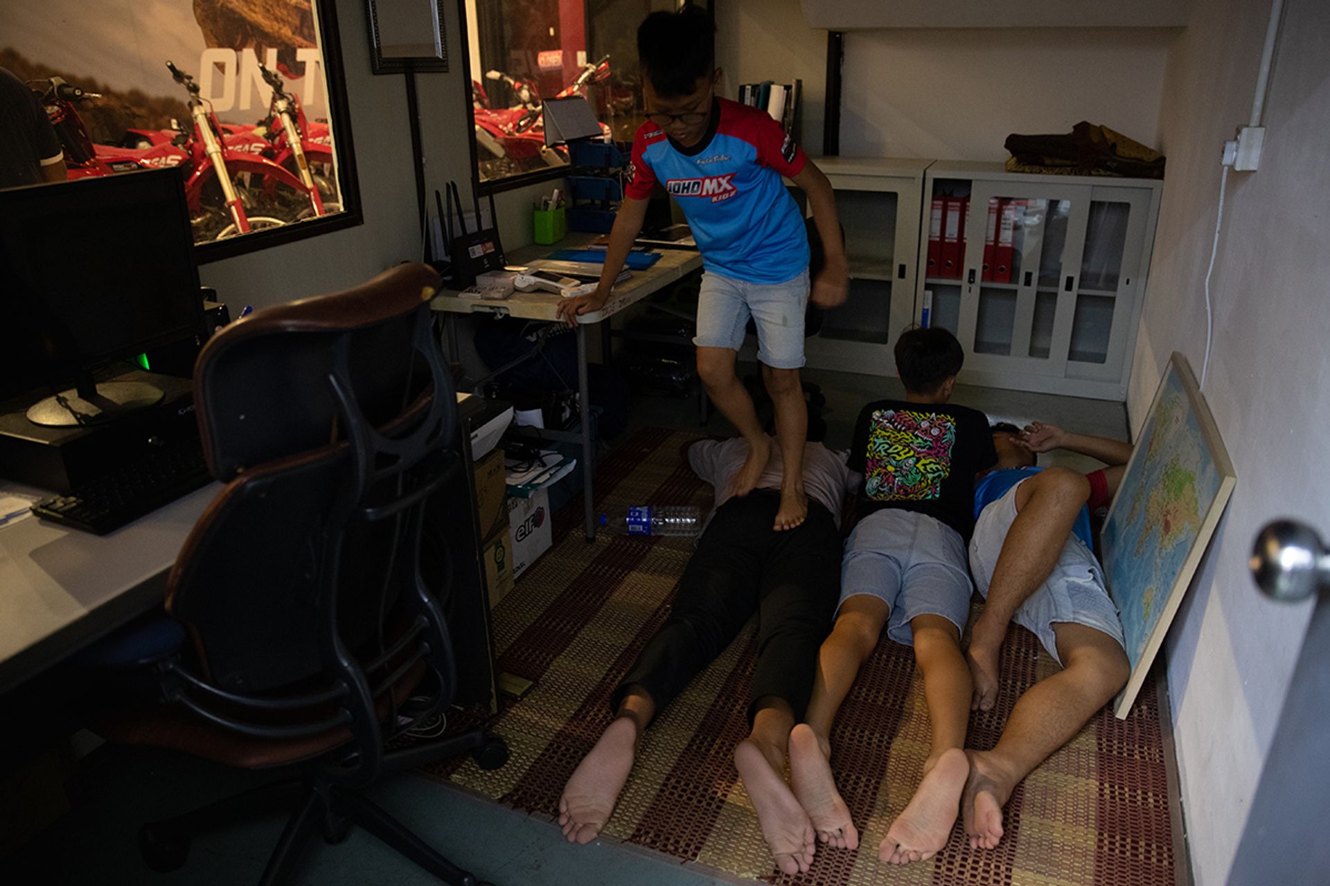 Iman stepping on Nurhaziq who was resting after training with Seth and Ian in the office at motorcycle workshop PGM Tech 23 in Johor on July 2.