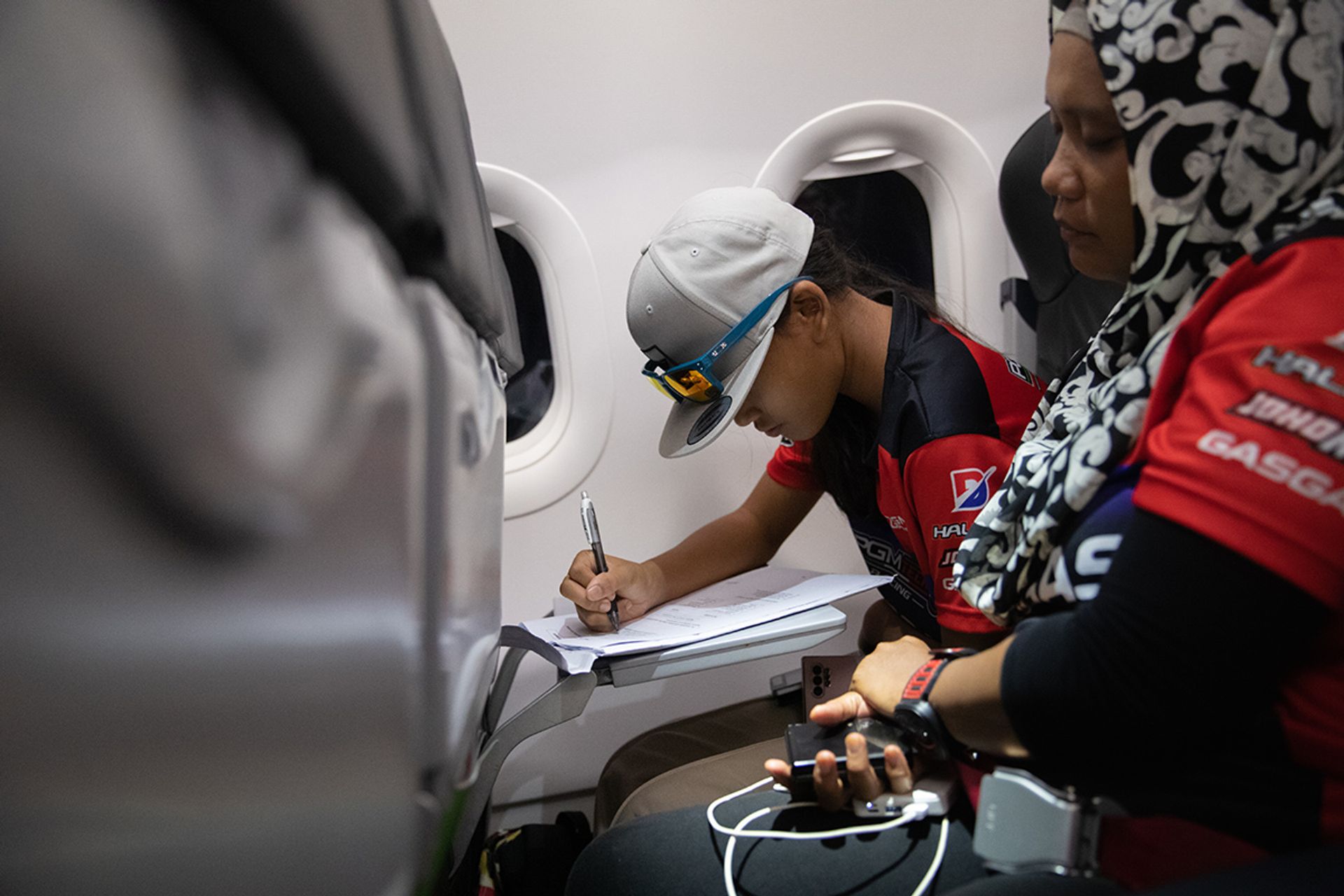 Iris rushing her homework on the plane.