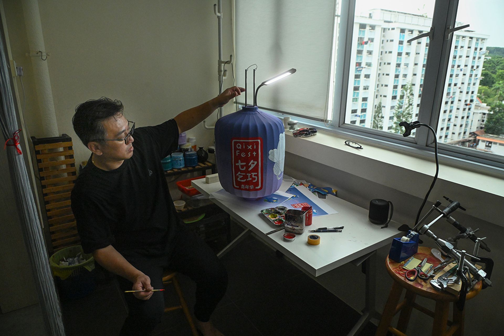 Mr Andy Yeo working at the balcony of his Bukit Batok home on lanterns he will use in live lantern painting demonstrations.
