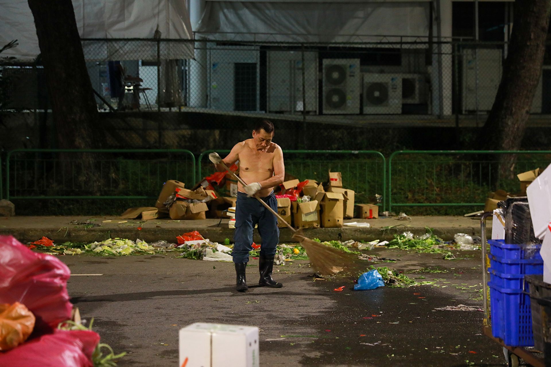 Mr Lew San Woon, 71, sweeping the street at the end of a night on May 6. For over 40 years, after selling vegetables every night, he would clear the rubbish for a small fee from the vendors.