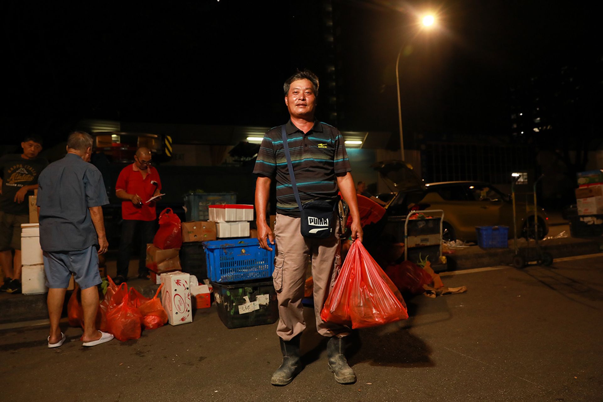 Construction site supervisor Xing Hong Fei, 51, with a bag of vegetables meant for three people. He visits the market daily after work at the nearby BTO project.