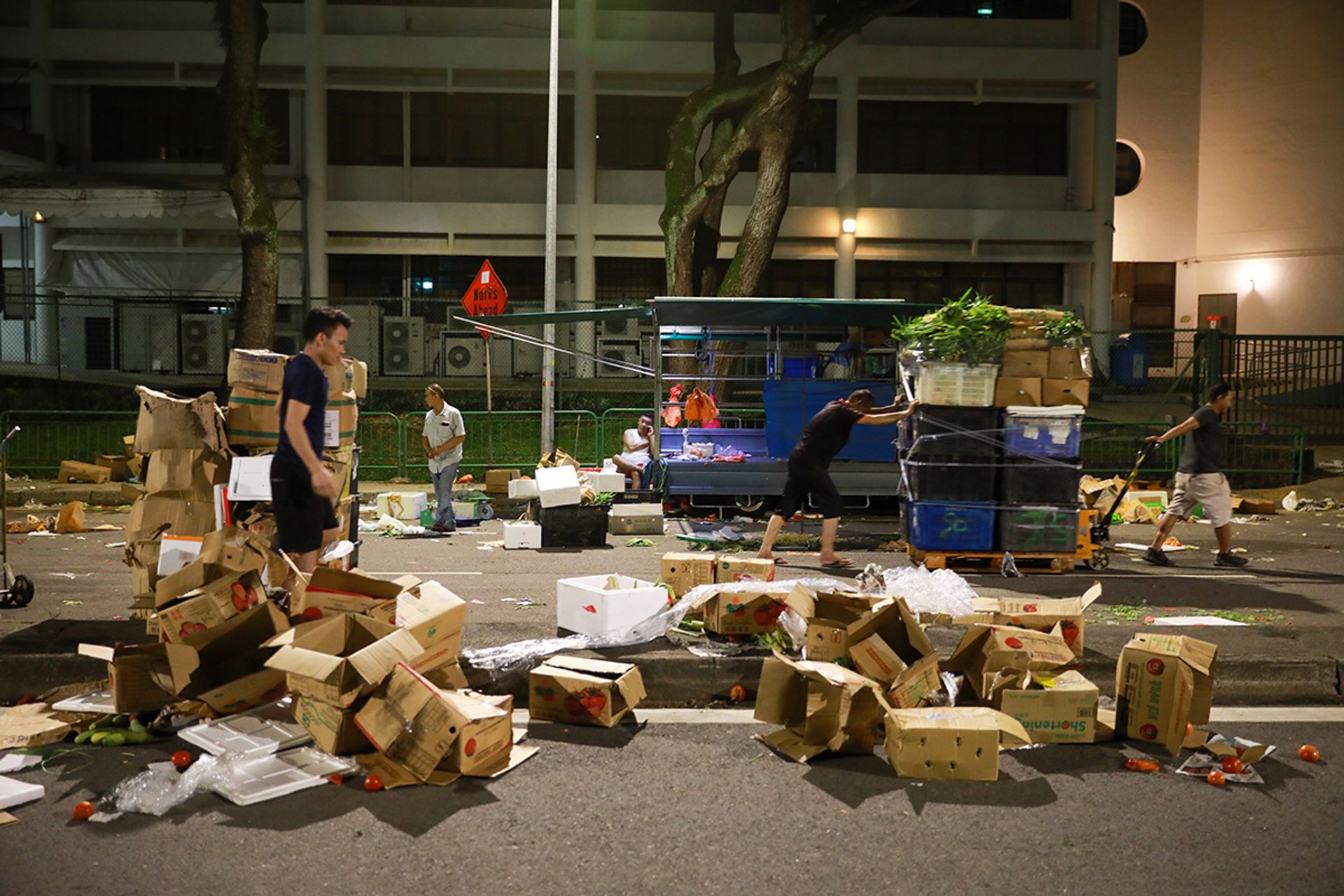 Workers packing the leftover greens into plastic cartons on May 6. Unsold vegetables are picked up by Willing Hearts, a local soup kitchen that prepares and distributes meals.