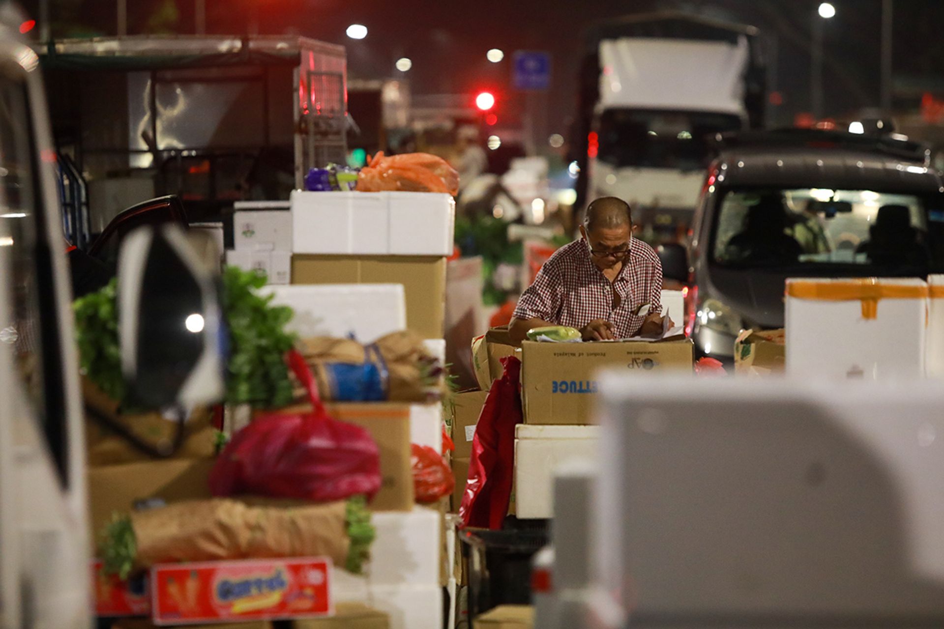 Mr Chan Kim Hong keeping tabs on the vegetables sold at the stall on April 17. He has spent over a decade working for Mr Ong Eng Seng and his son Ong Chai Meng, dealing with regular customers who would purchase bulk standing orders.