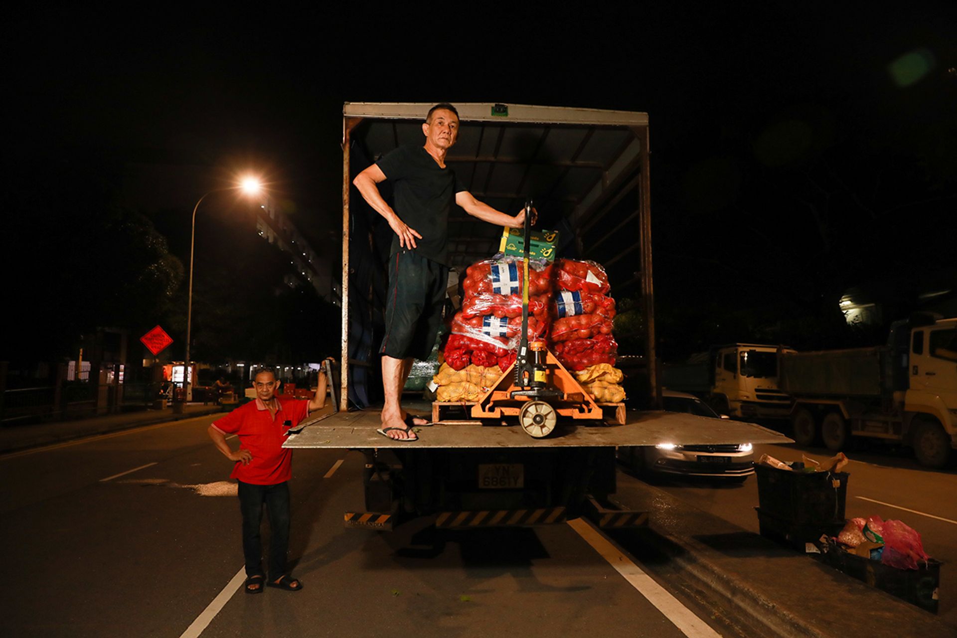 Mr Yang Hui (in black), 60, and Mr Chan Kim Hong (in red), 65, preparing for another busy night on July 1.