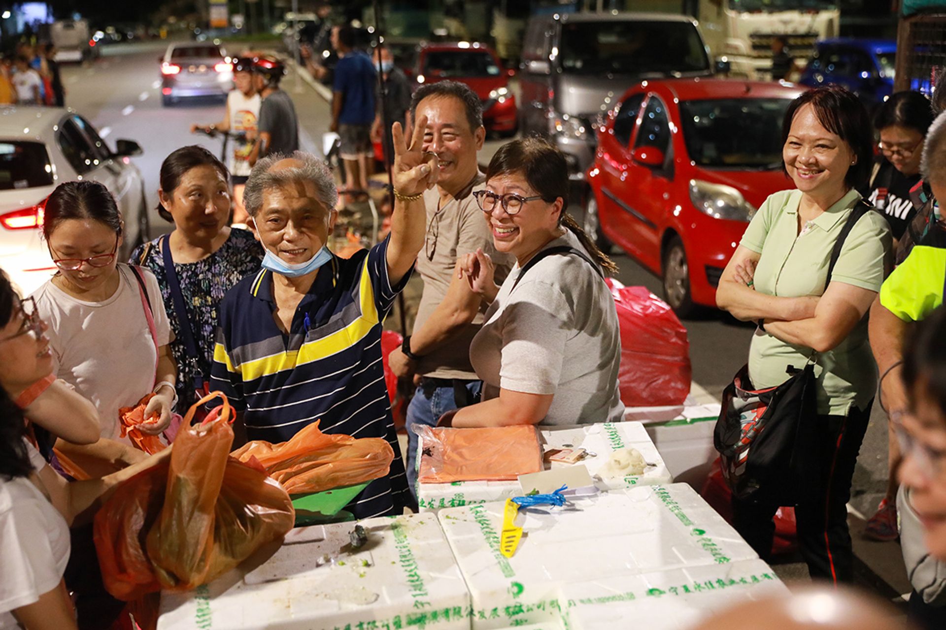 Mr Ong Eng Seng posing with his customers on July 1. A larger-than-usual crowd turned up on his last day of business. Curious first-time visitors came to see the market before it is closed for good on Aug 19, while long-time customers dropped by to bid farewell.