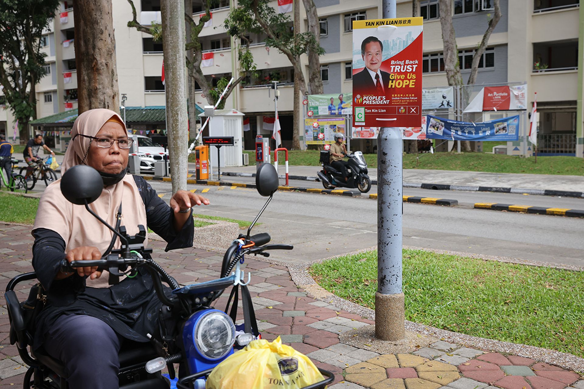 Residents passing by Mr Tan's campaign poster near Chong Pang Market & Food Centre on Aug 26, 2023. ST PHOTO: ONG WEE JIN