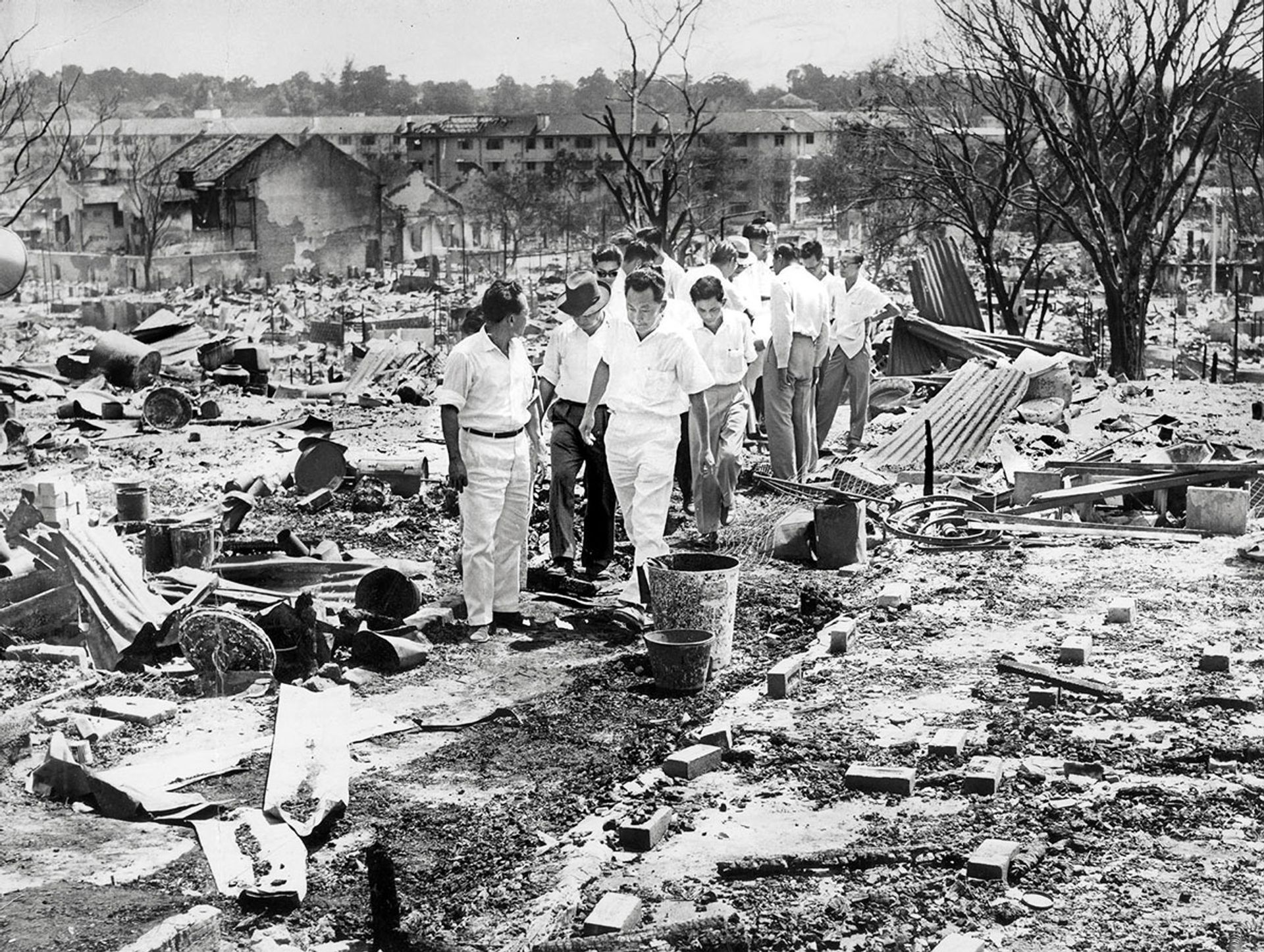 The Bukit Ho Swee fire on May 25, 1961, razed the entire area to the ground, killing four, injuring 85 others and rendering 16,000 homeless. Mr Lee (third from left), with National Development Minister Tan Kia Gan (left), visited the site after the fire was put out. The Government moved quickly to provide housing for the victims. In February the following year, HDB completed new flats in the area to provide shelter for 1,900 families affected by the fire. Source: The Straits Times