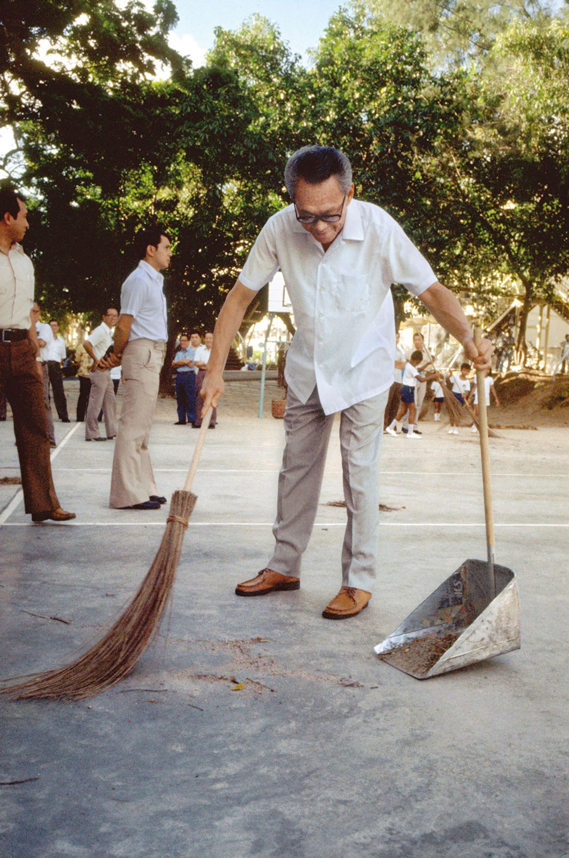 Mr Lee was not above picking up the broom when he visited schools in the Keppel and Cantonment areas to see how students there took part in the Use Your Hands campaign on May 27, 1978. The campaign sought to inculcate healthy attitudes towards manual work among students. Source: MCI Collection