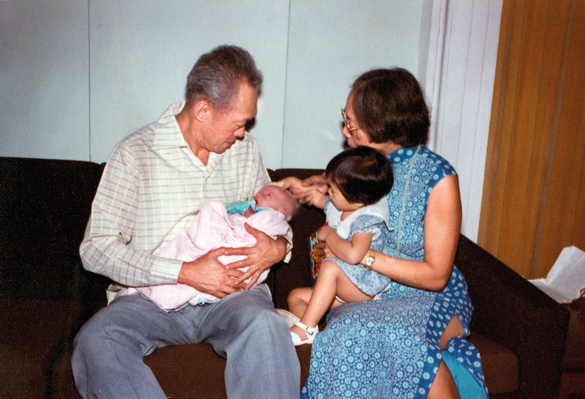 Mr Lee Kuan Yew carrying his first grandson Yipeng, while Mrs Lee guides only granddaughter Xiuqi, two, as she strokes Yipeng on his head, in 1982. The couple have seven grandchildren. Source: Lee Kuan Yew