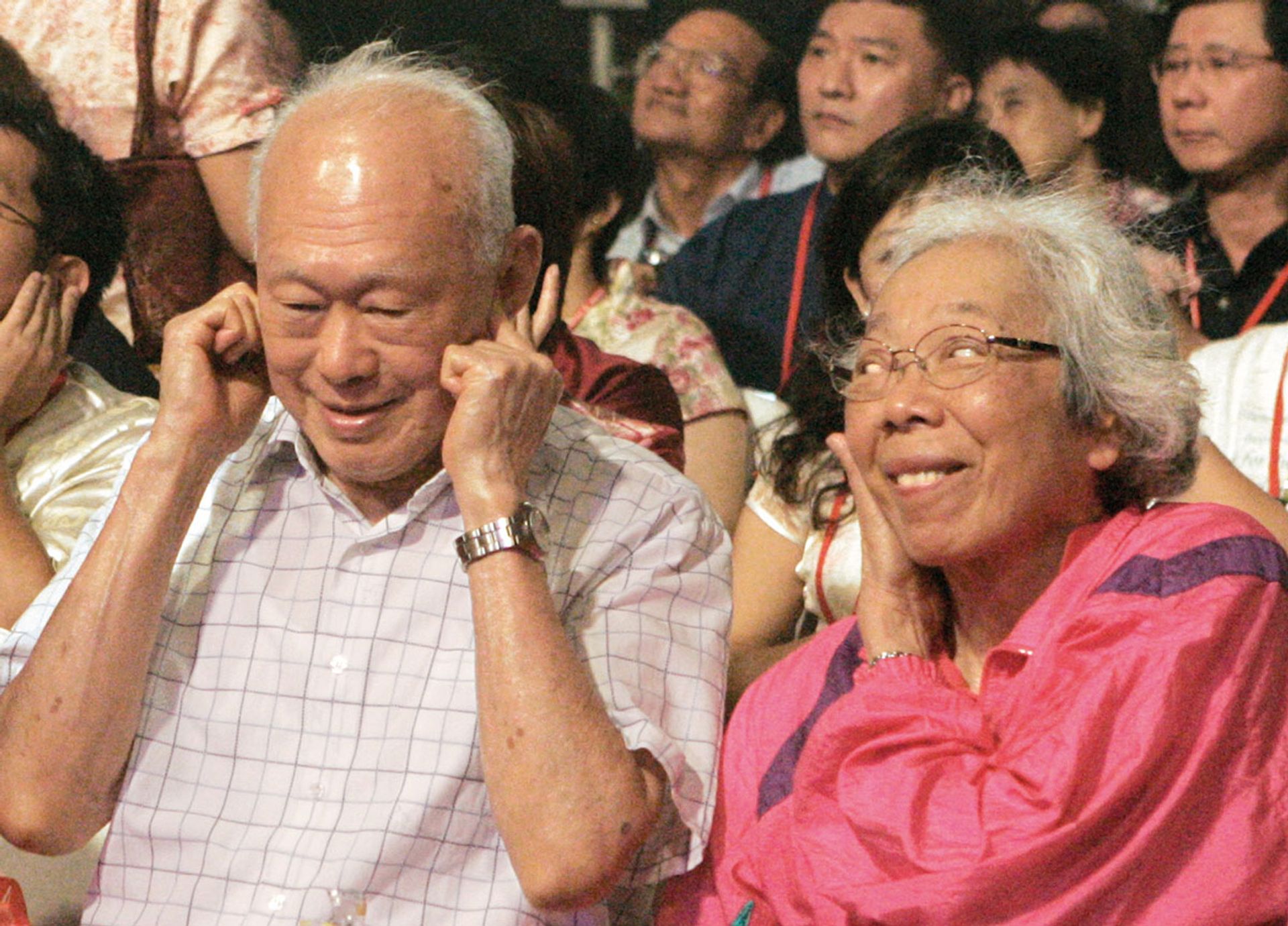 Mrs Lee glancing at Mr Lee covering his ears as firecrackers explode at a Chinese New Year light-up in Chinatown on Jan 7, 2006. ST Photo: Bryan van der Beek
