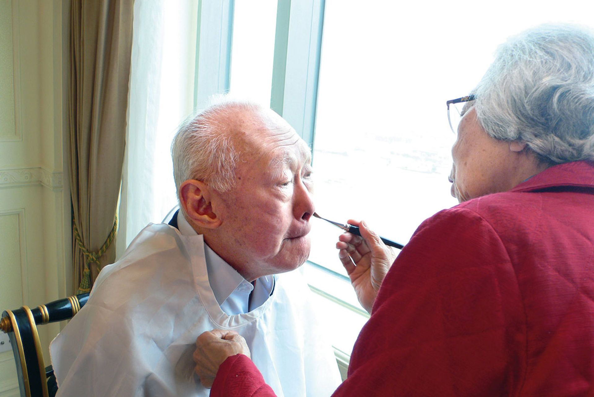 Mrs Lee applying Mr Lee’s make-up at Pudong Shangri-La hotel before a TV appearance in Shanghai on May 17, 2006. Photo: Li Xiuqi