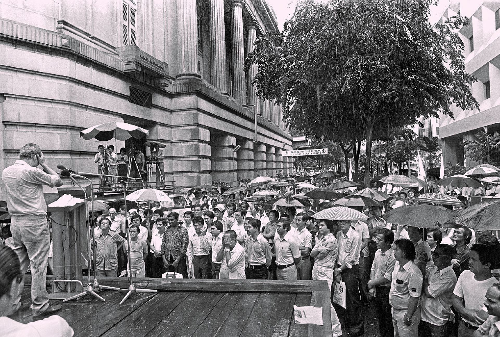 Mr Lee campaigning in the rain during a lunchtime rally at Fullerton Square on Dec 19, 1980. The crowd braved the downpour to hear him speak. ST Photo: Mazlan Badron