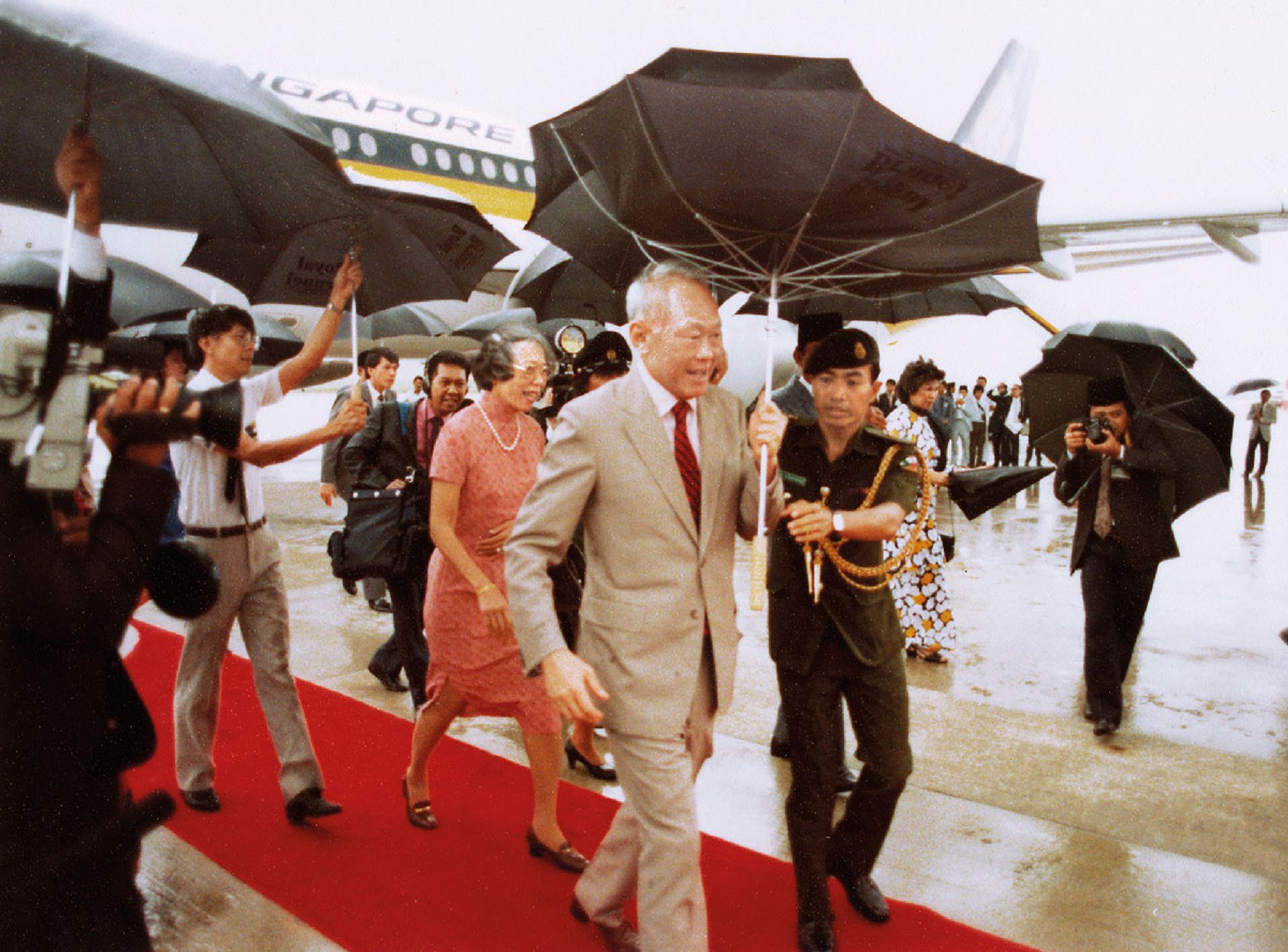 No raining on his parade: Mr Lee smiling as his umbrella proves no match against the stormy weather that greeted him and Mrs Lee on their arrival in Brunei in August 1986. Source: Lee Kuan Yew