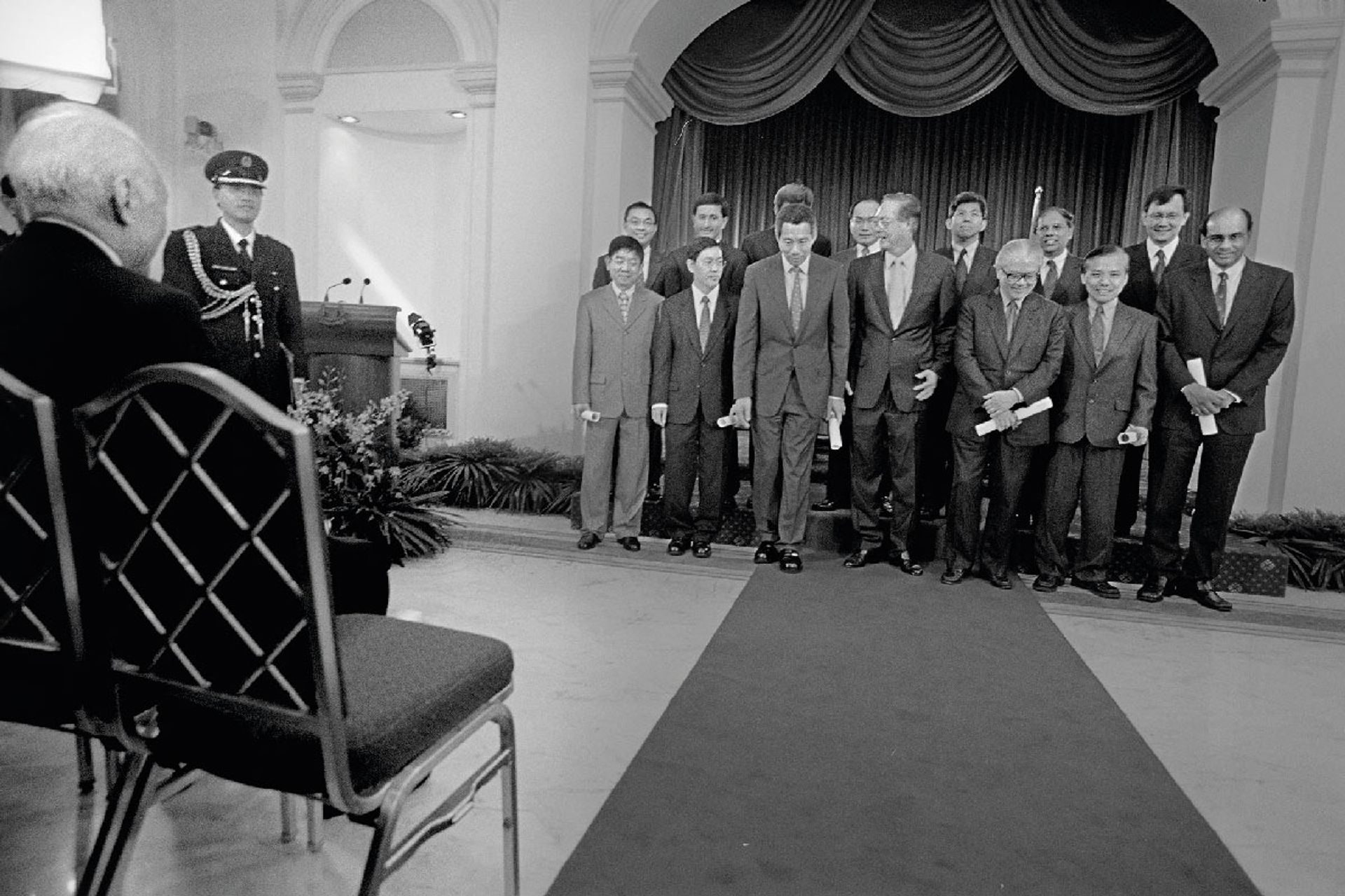 Taking their places for the camera: Mr Lee (seated) watching as his parliamentary colleagues arrange themselves for a photo after being sworn in on Nov 23, 2001. (First row from left) Senior Ministers of State Khaw Boon Wan and Matthias Yao, Deputy Prime Minister and Finance Minister Lee Hsien Loong, Prime Minister Goh Chok Tong, Deputy Prime Minister Tony Tan, Senior Ministers of State Ho Peng Kee and Tharman Shanmugaratnam. (Second row from left) Ministers of State Cedric Foo, Vivian Balakrishnan, Ng Eng Hen, Chan Soo Sen, Yaacob Ibrahim, Balaji Sadasivan and Raymond Lim. ST Photo: George Gascon