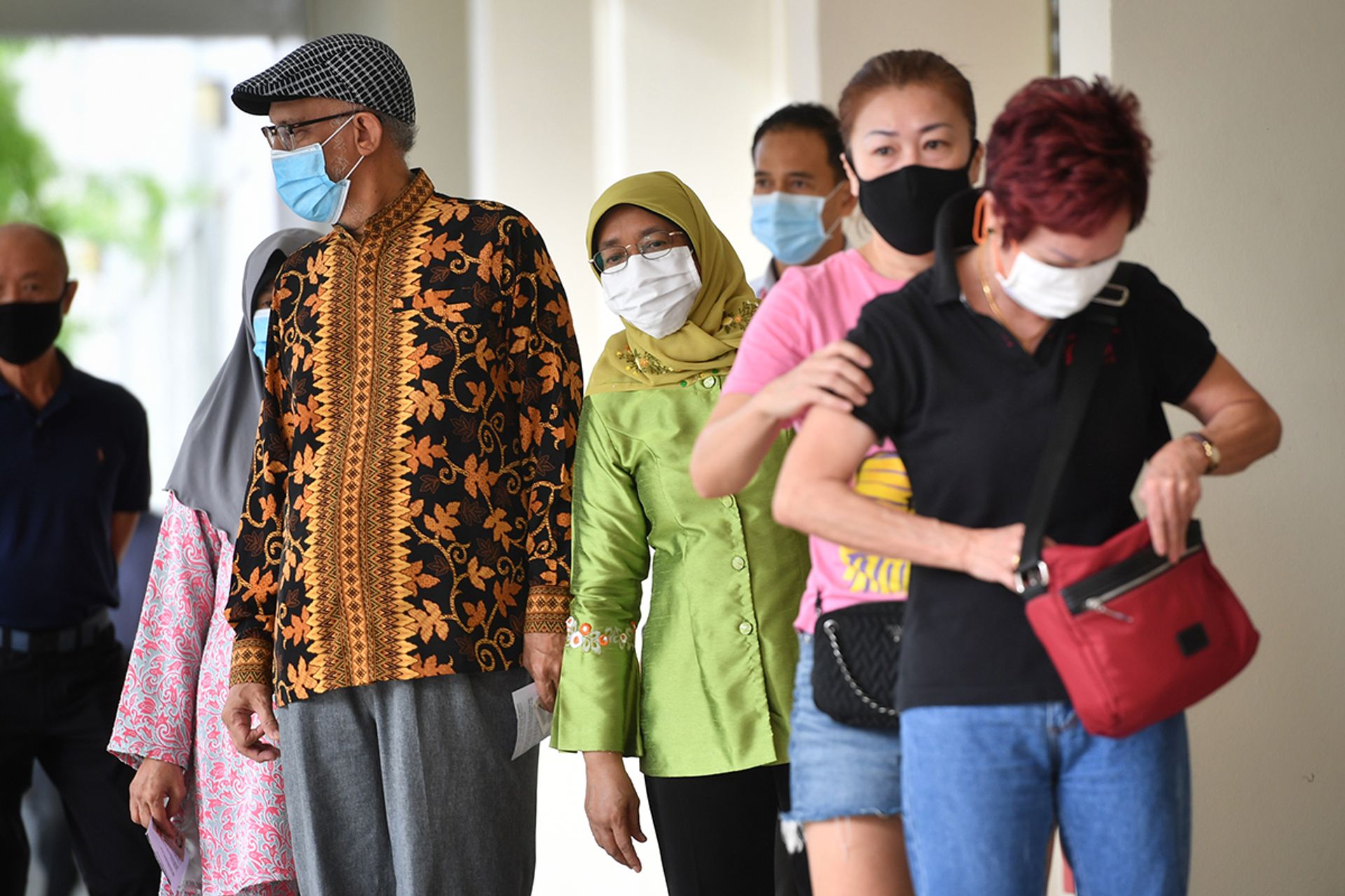 President Halimah and her husband, Mr Mohamed Abdullah Alhabshee, queuing to cast their votes at Chung Cheng High School (Main) at the 2020 General Election on July 10, 2020. ST PHOTO: CHONG JUN LIANG