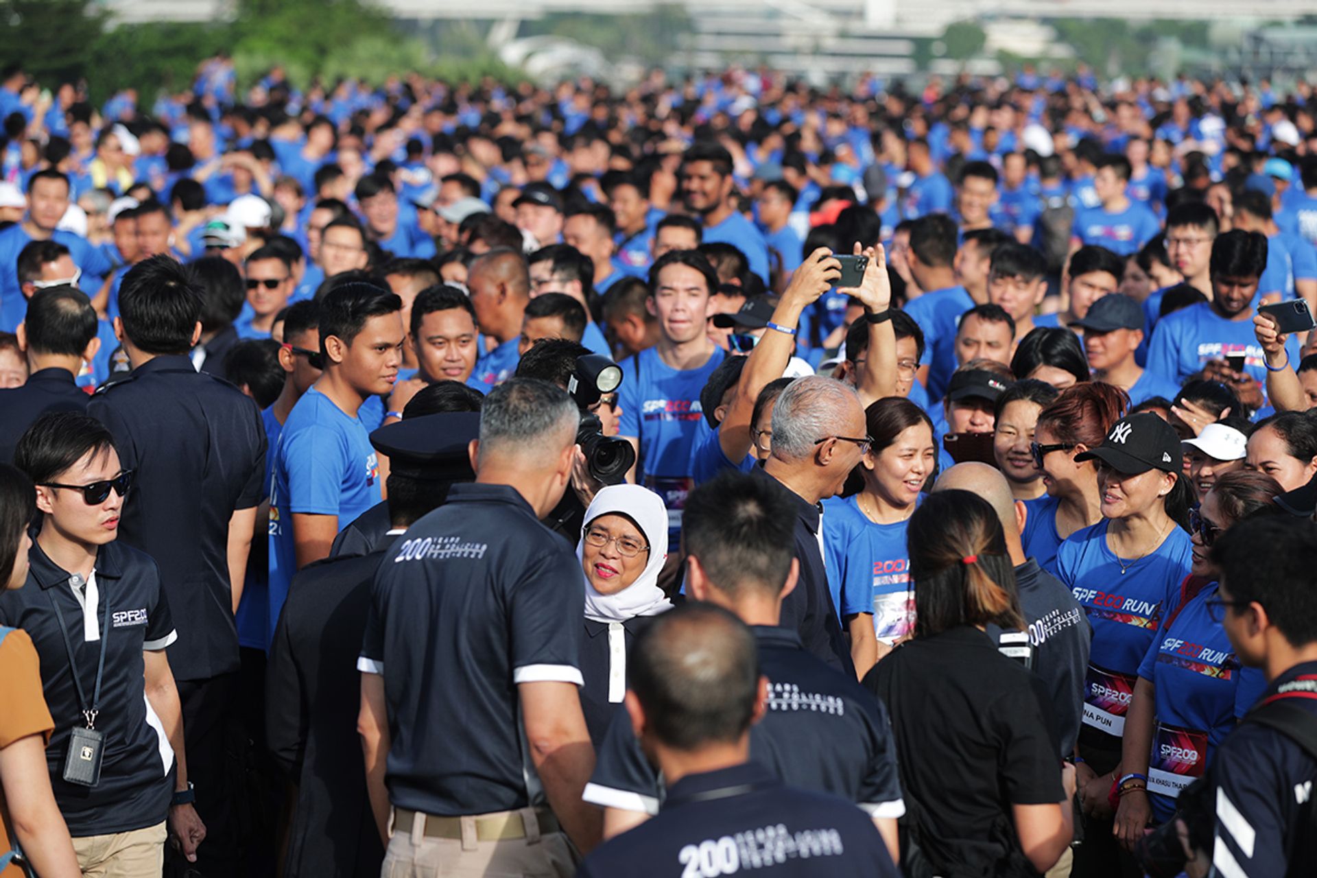 President Halimah (centre, in white) mingling with runners at the Marina Barrage before the start of the Singapore Police Force Bicentennial (SPF200) Run on Jan 11, 2020. Madam Halimah was the guest of honour at the event. ST PHOTO: KELVIN CHNG