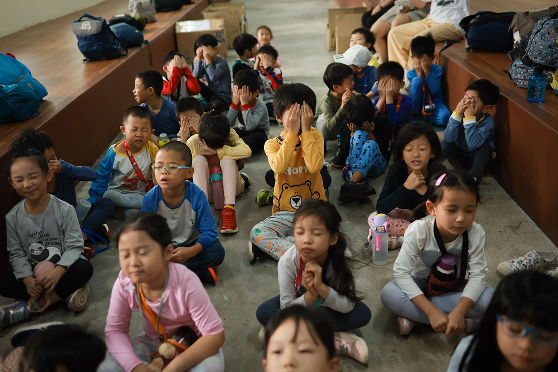 Children close their eyes in anticipation of a surprise. It is a camp tradition on the last day to present to the children letters of support and encouragement from their families.