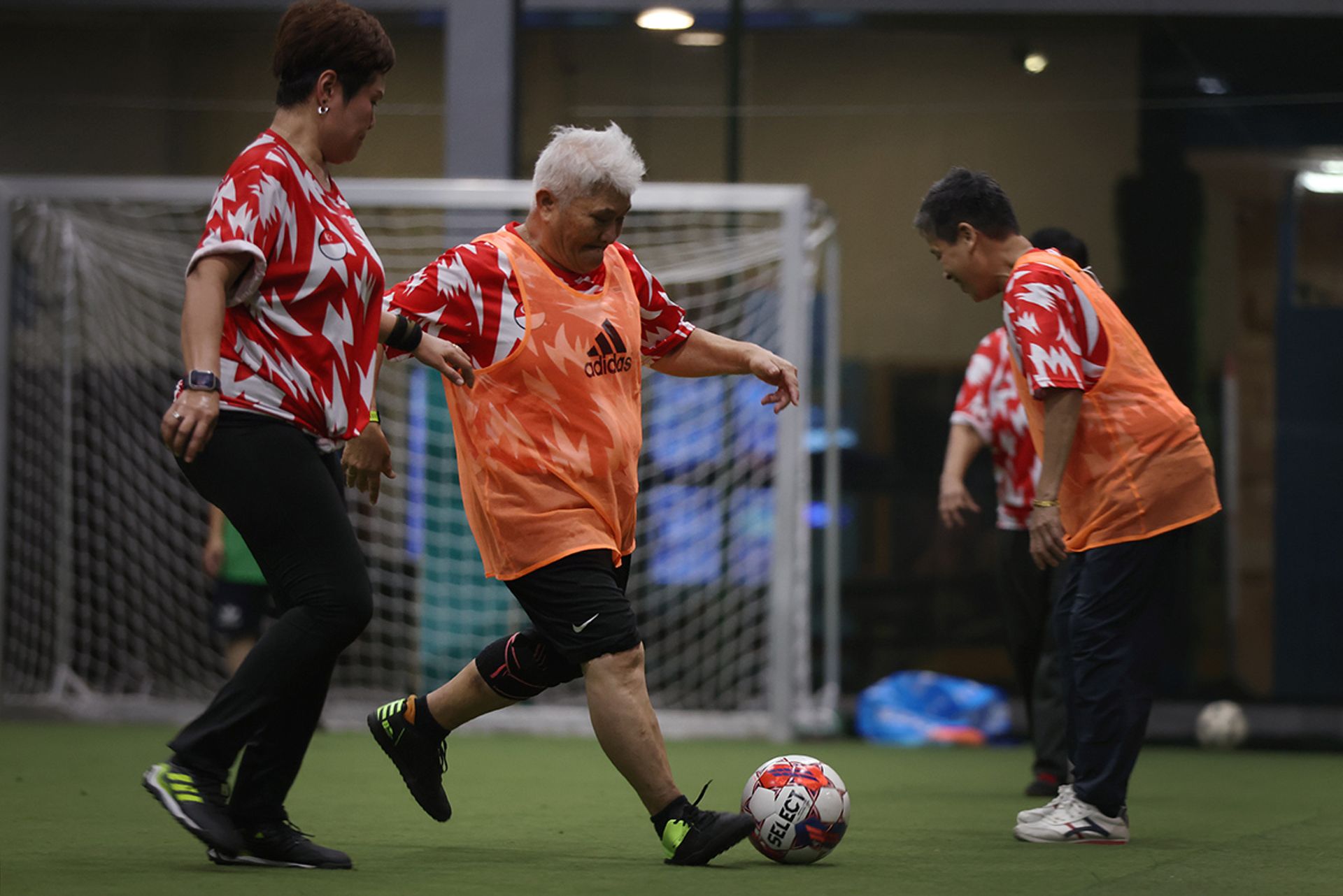 Madam Maimun Wahab attempting to dribble past Madam Shasha Ashita (left), 51, during a practice at ActiveSG Hockey Village in Boon Lay.