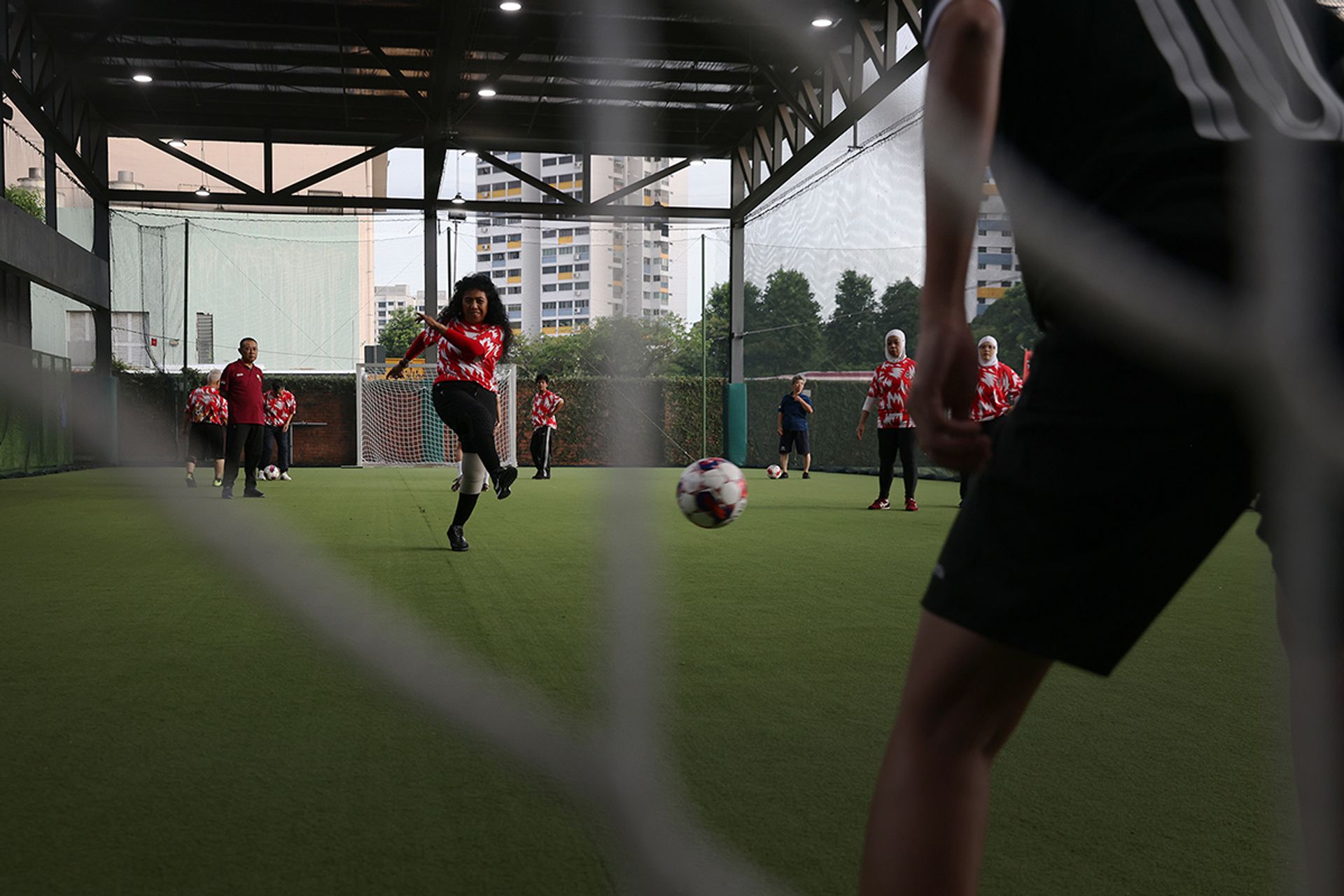 Madam Merah Ahmad, 66, practising her shooting. Now a grandmother of three, Madam Merah used to play as a defender in the national team but roams further up the pitch today.