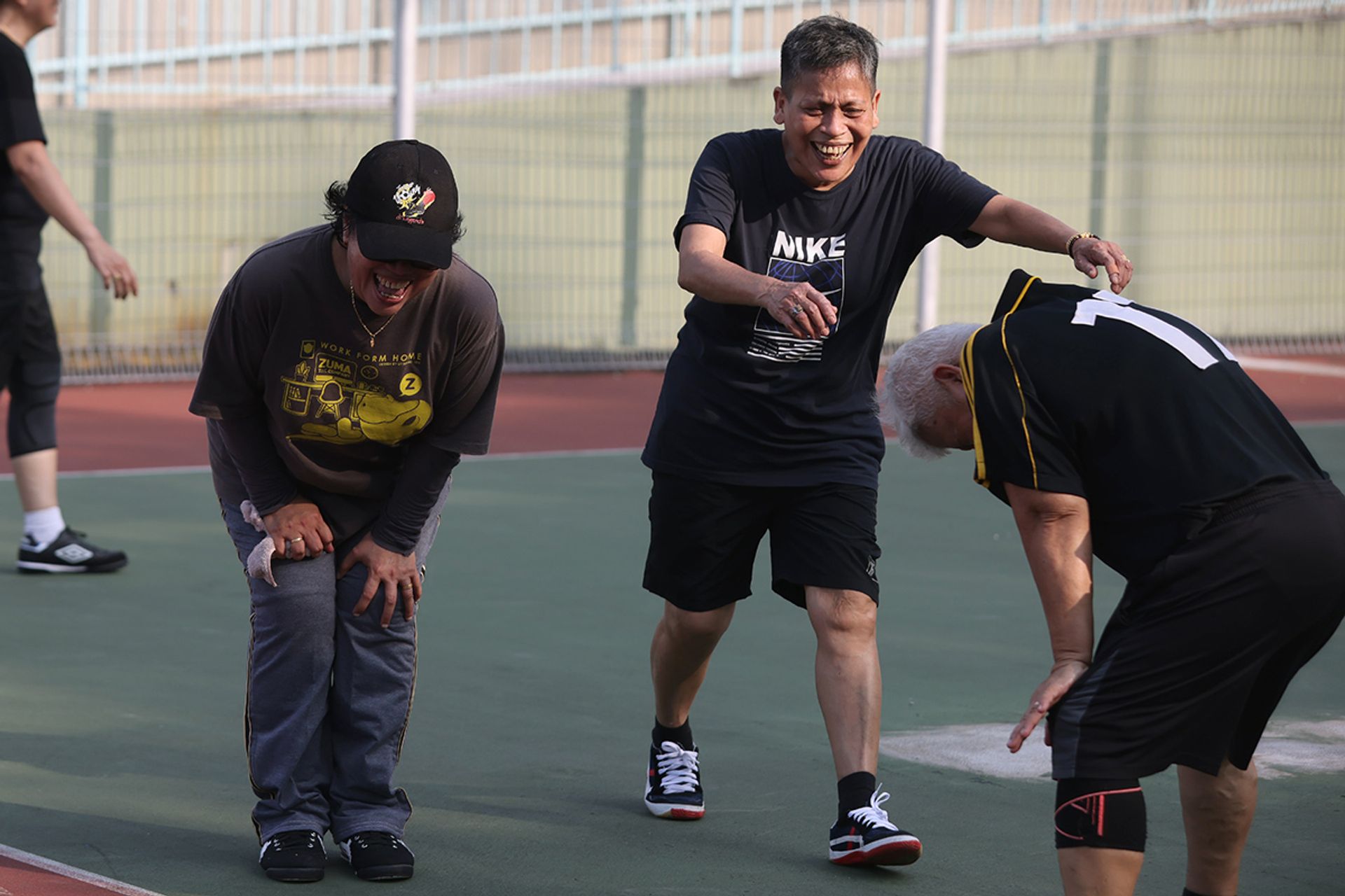 Madam Maimun Wahab, Madam Fauziah Joo and Madam Rogayah Mohd sharing a laugh during a practice at the MOE (Evans) futsal court.