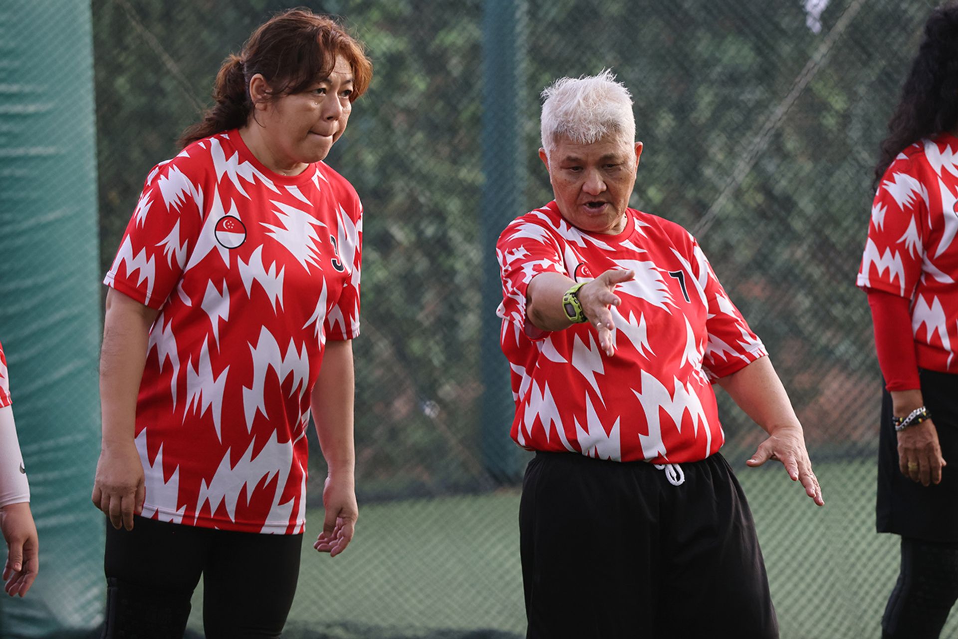 Madam Syurya Elias (left) getting some tips from Madam Maimun Wahab during a training session at ActiveSG Hockey Village in Boon Lay.