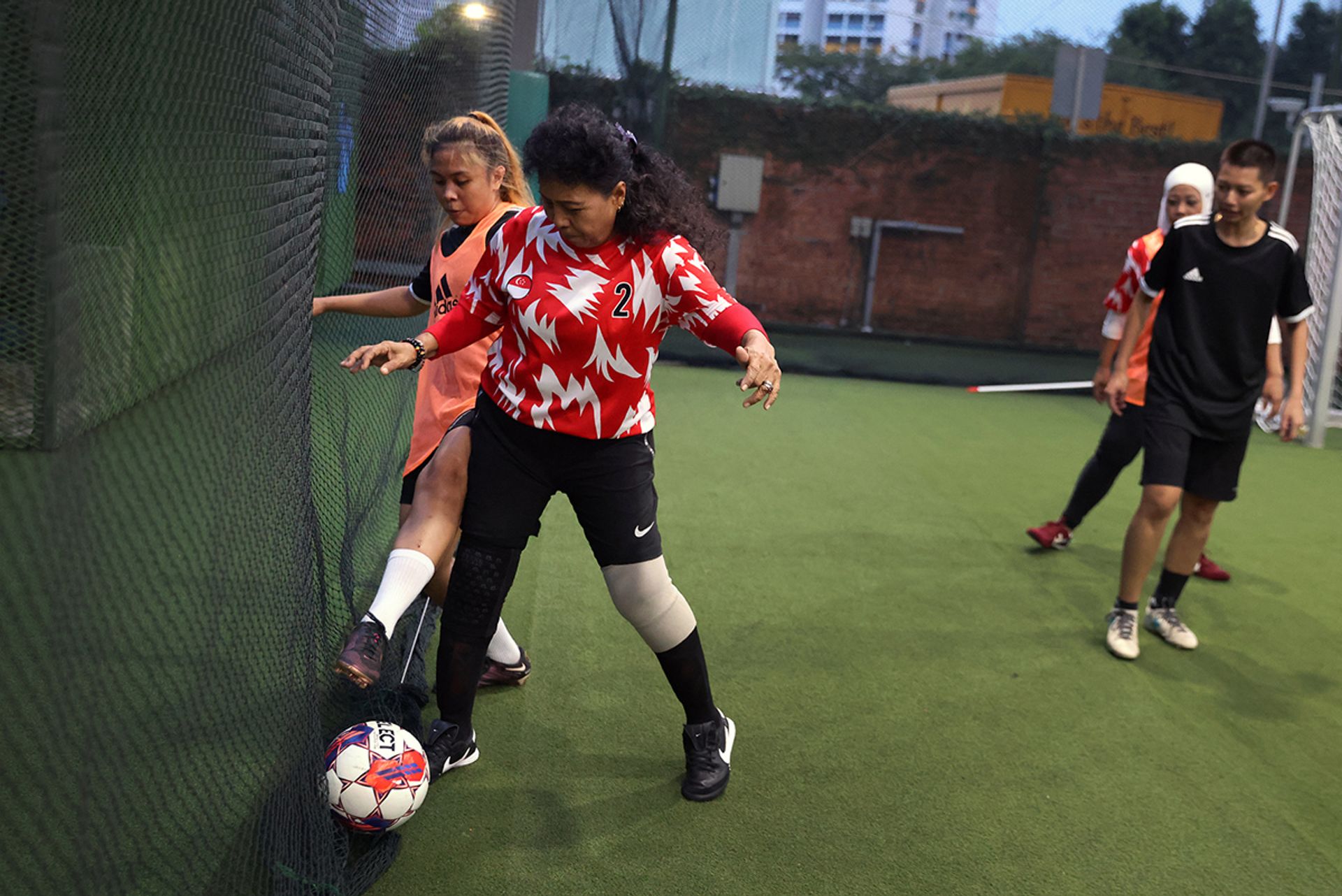 Ms Nur Hanis Amira (left) challenging Madam Merah Ahmad during a training session at ActiveSG Hockey Village in Boon Lay.