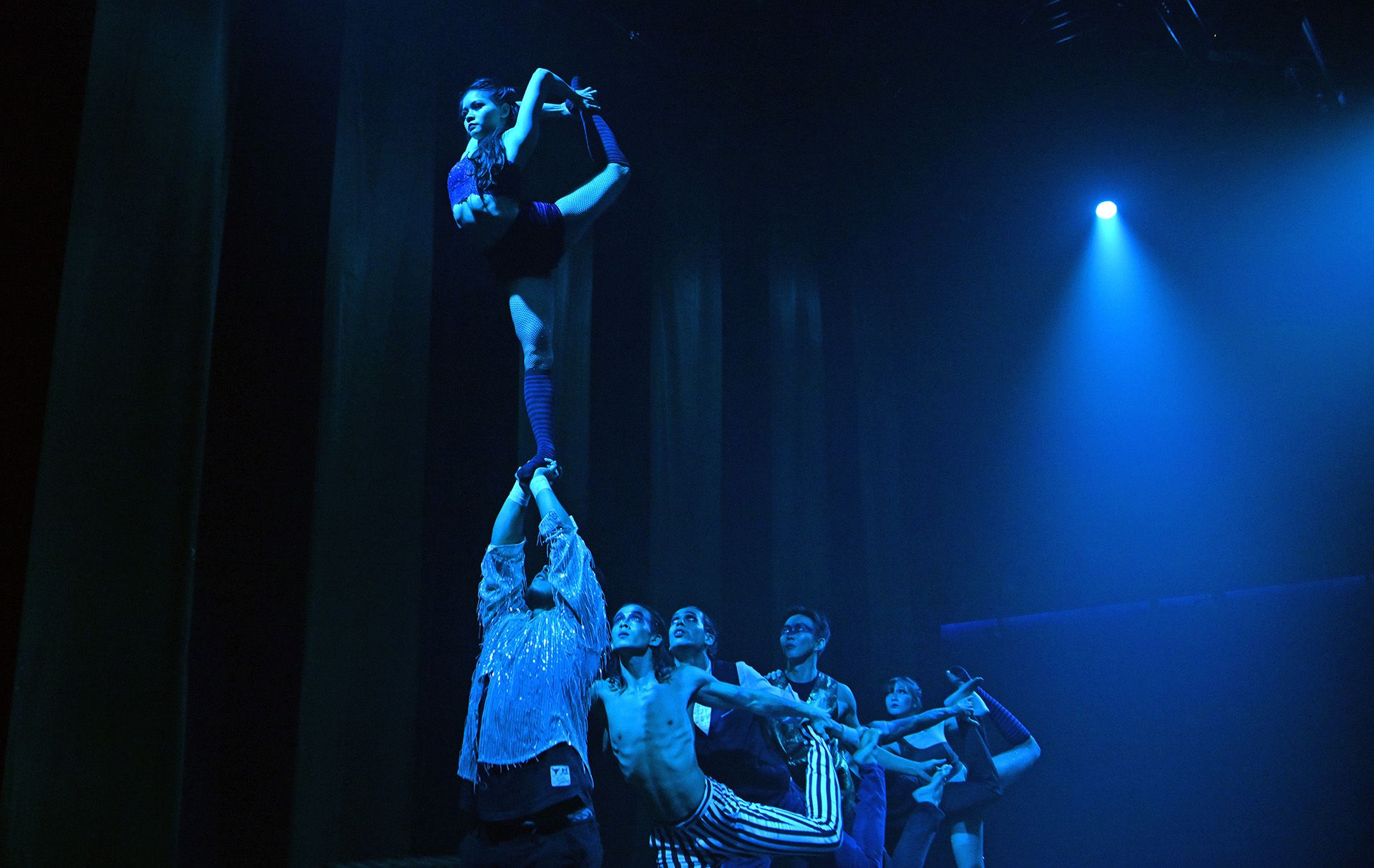 One of the most difficult routines of the show has Ms Wan nimbly steering her way on the shoulders of five troupe members to perch herself on the palms of Mr Yap.