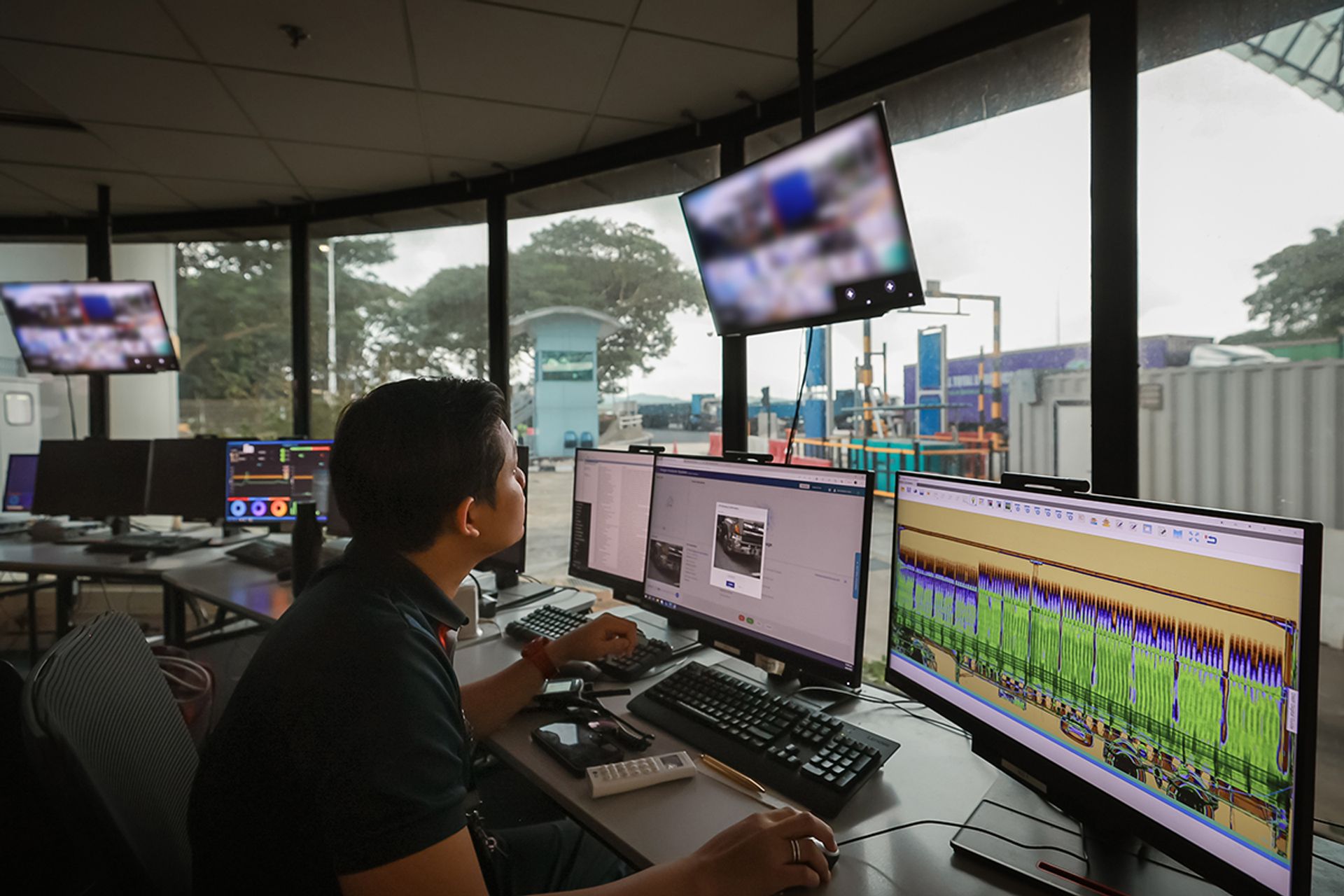 An ICA officer looking at X-ray scans of lorries and their cargo at Tuas Checkpoint. ST FILE PHOTO: GAVIN FOO