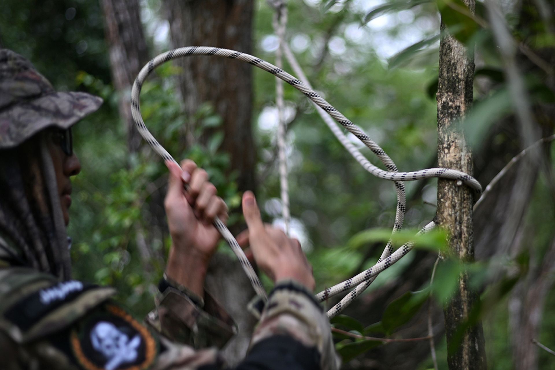 Mr Ahmad Abdullah skilfully tying a knot to secure an anchor point as his family members prepare to rappel down a steep slope at Tampines Quarry.