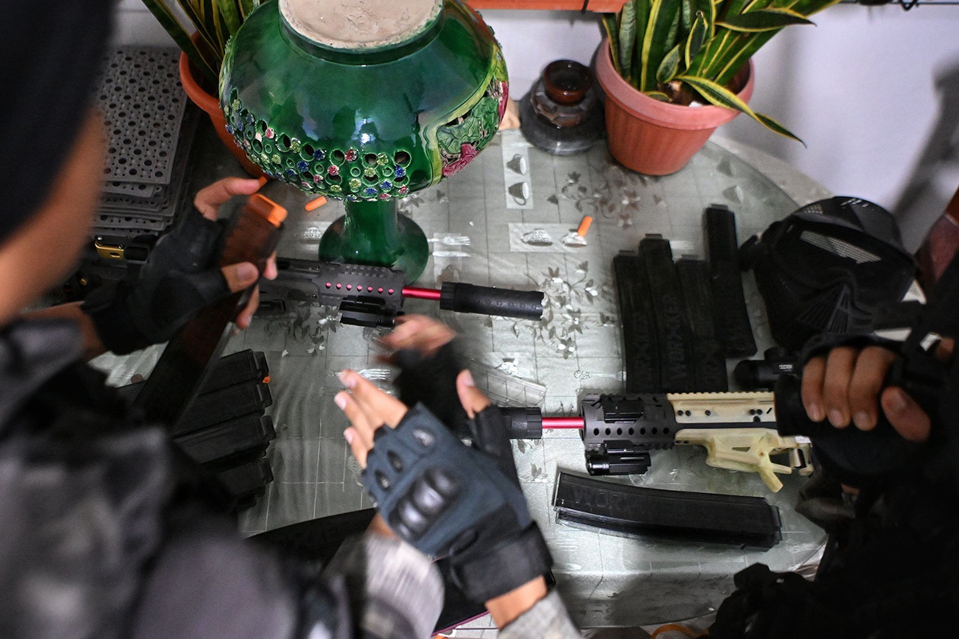 (From left) G.H.O.S.T. equipment specialist Mohd Afnan inspecting every detail of his cutting-edge Black Raisins foam dart blaster magazine, assessing the equipment’s functionality before passing it to his older brother, Mr Mohd Wira.