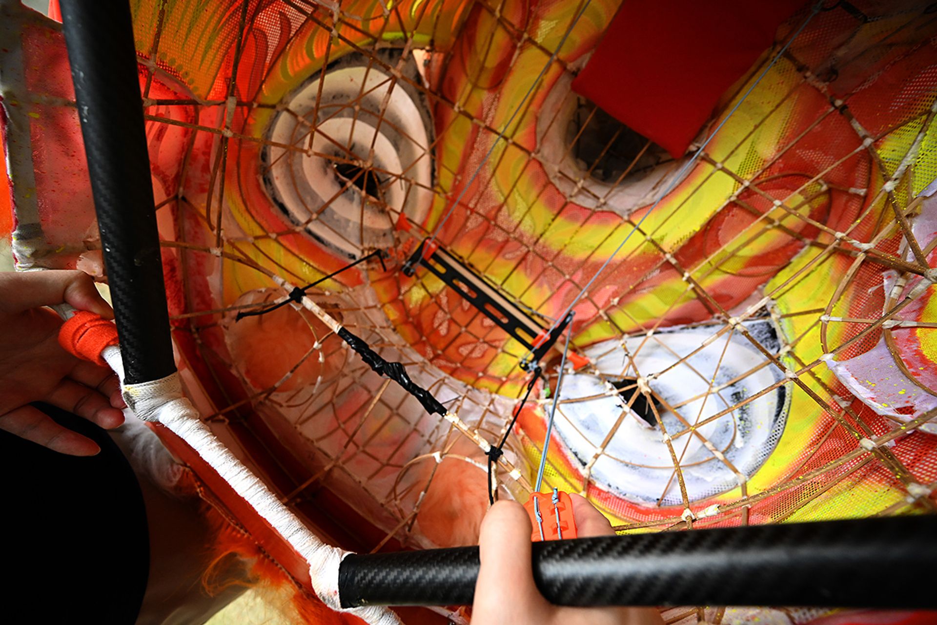 A 3D-printed pulley and lever system, designed by NextOfKin Creatives, which can be clamped on to existing lion dance heads to make the blinking of eyes and flapping of ears easier.