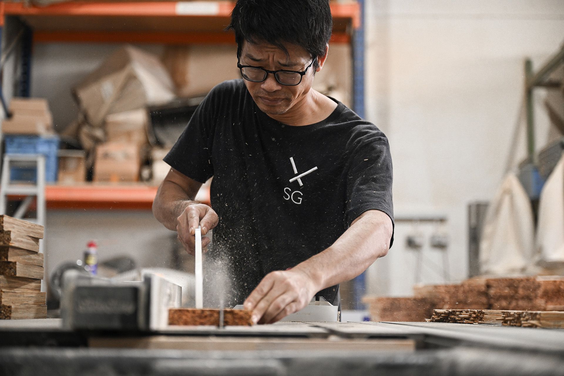 Carpenter Zheng Liangqi cutting a freshly pressed tile with a table saw.