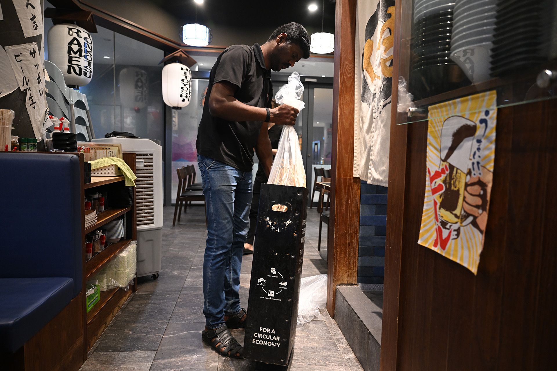 Mr Babu collecting a bag of chopsticks from Ramen Hitoyoshi restaurant at Our Tampines Hub.