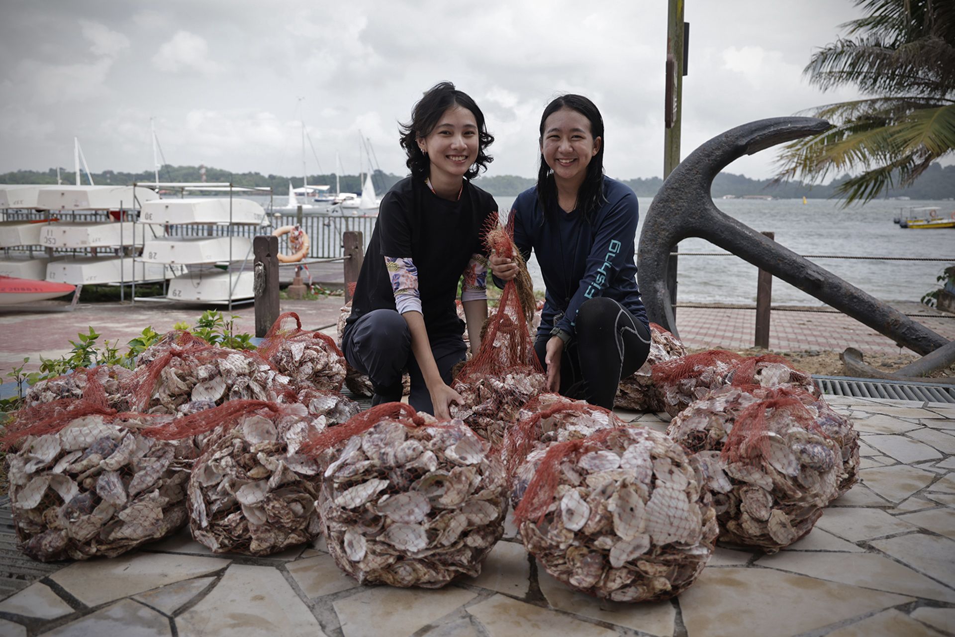 Ecologists Yukie Yokoyama (right), 27, and Erika Ng, 24, with bags of oyster shells.