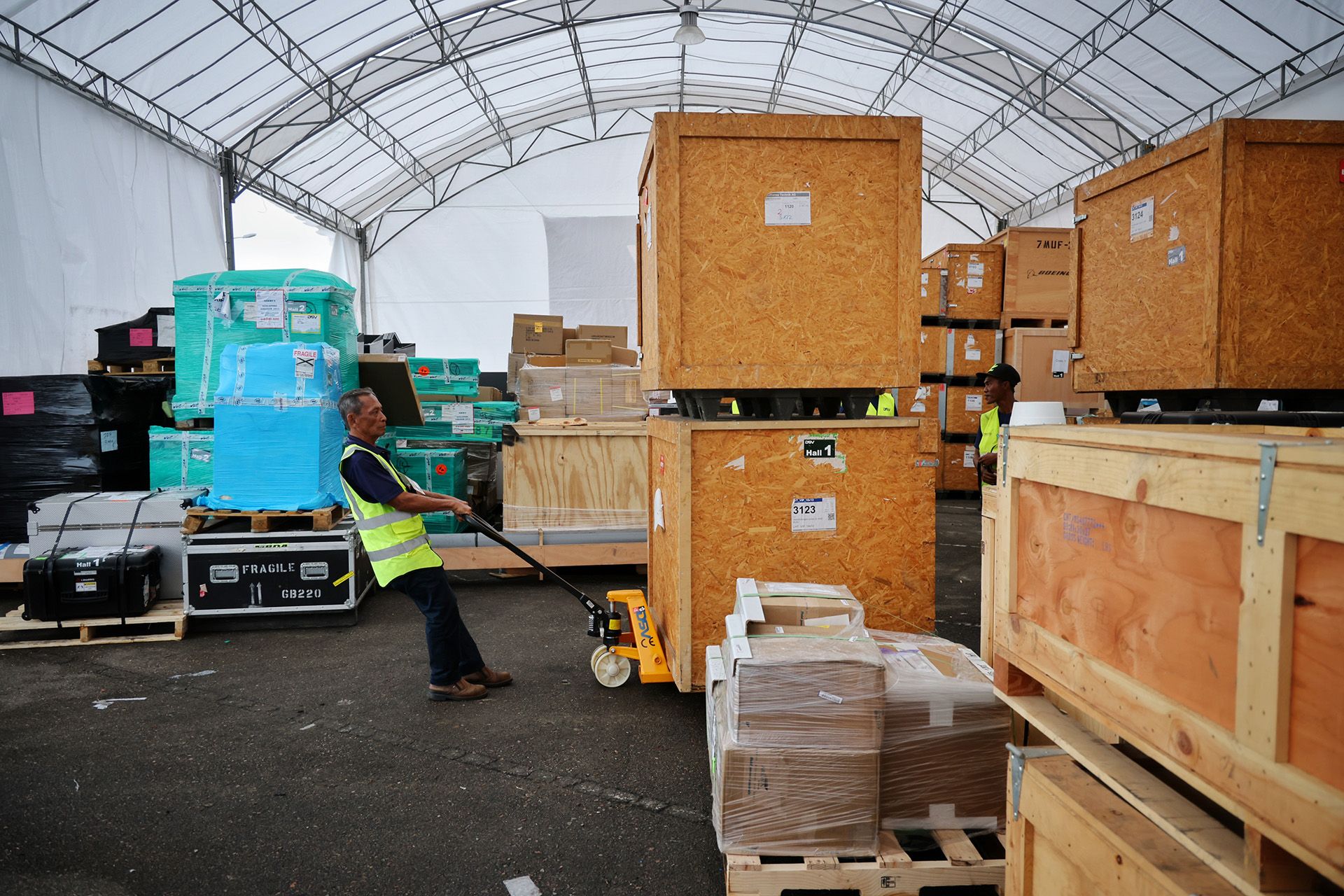 Workers moving crates of exhibition booth materials at the Changi Exhibition Centre on Feb 15. ST PHOTO: JASON QUAH